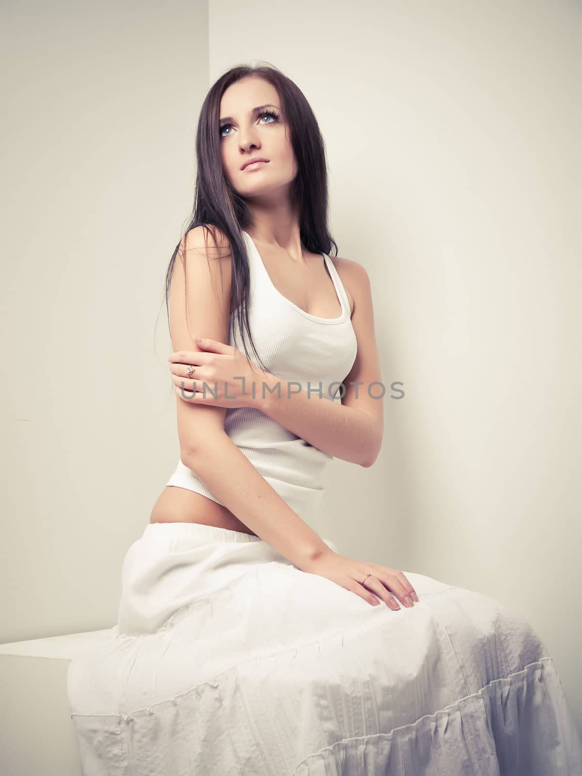 Model in white dress posing in a studio