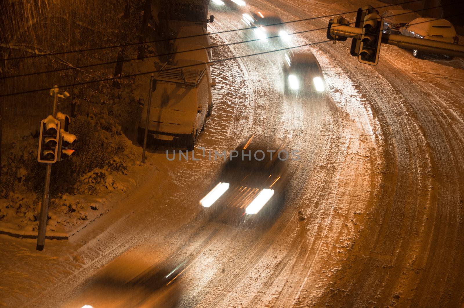 Main street covered with fresh snow and cars finding their way at night