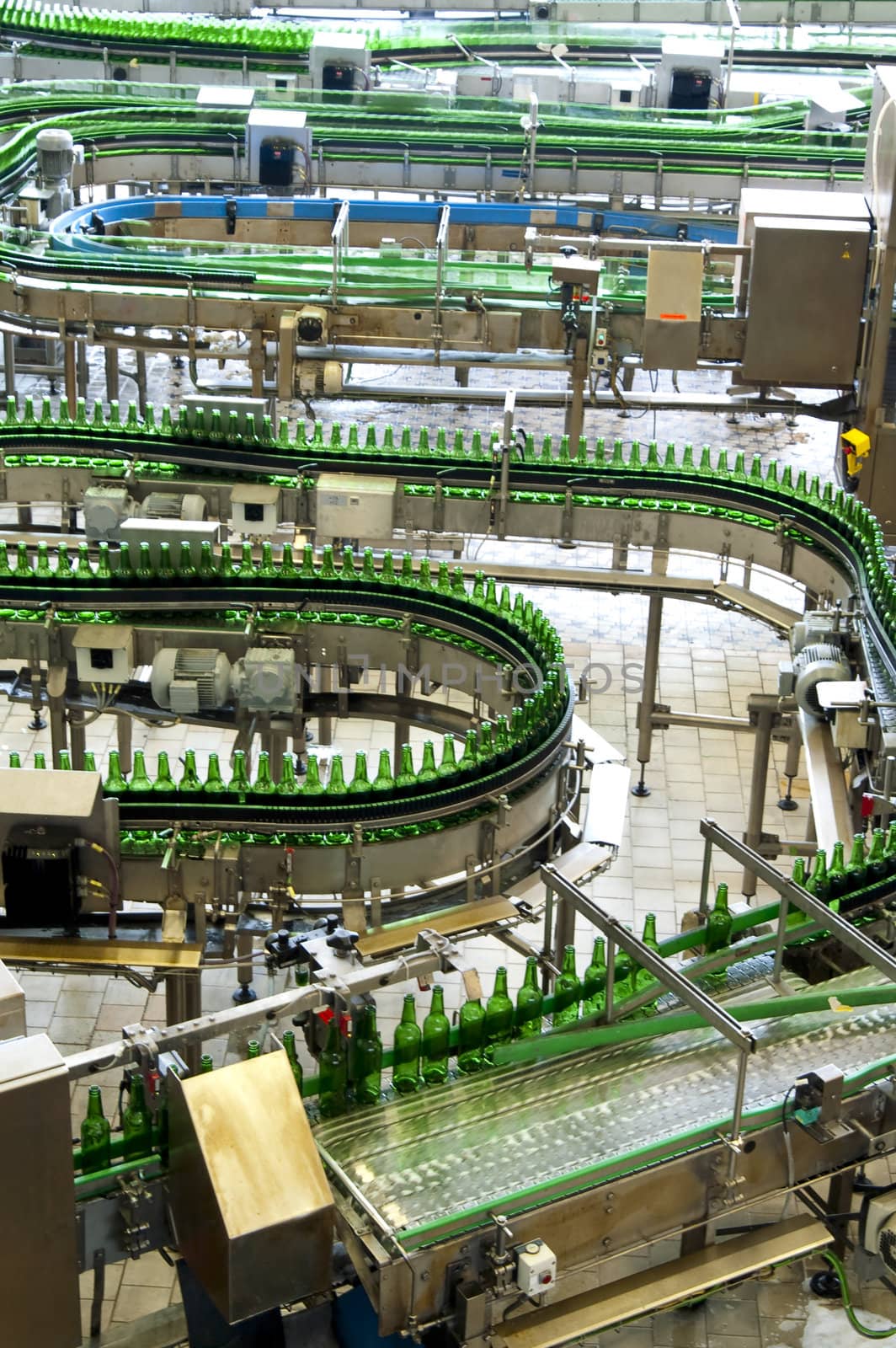 Budvar, Czech Republic - August 12:  Rows of green beer bottles going through a brewery line in Czech.  One of the most famous breweries in 2009.