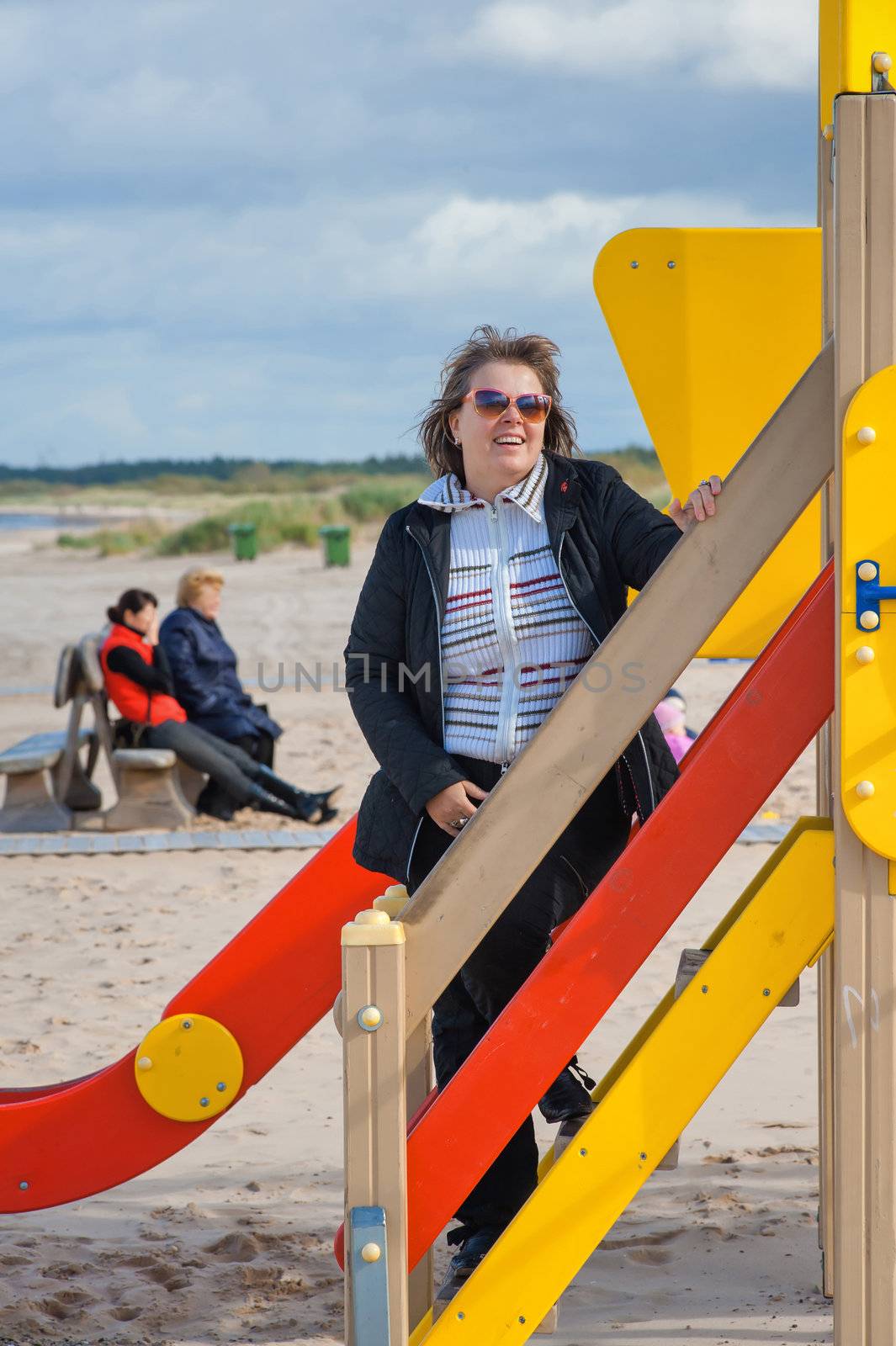 Mature  woman relaxing in dune at the Baltic sea in autumn day.
