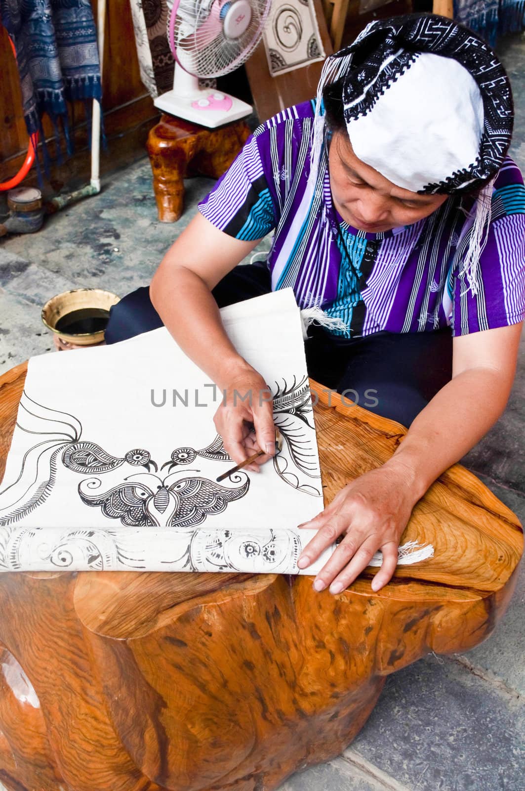 Xijiang, China - July 05:  A traditional woman making a Batik Tapestry in Xijiang, China.  A very traditional technique that is popular among tourists.