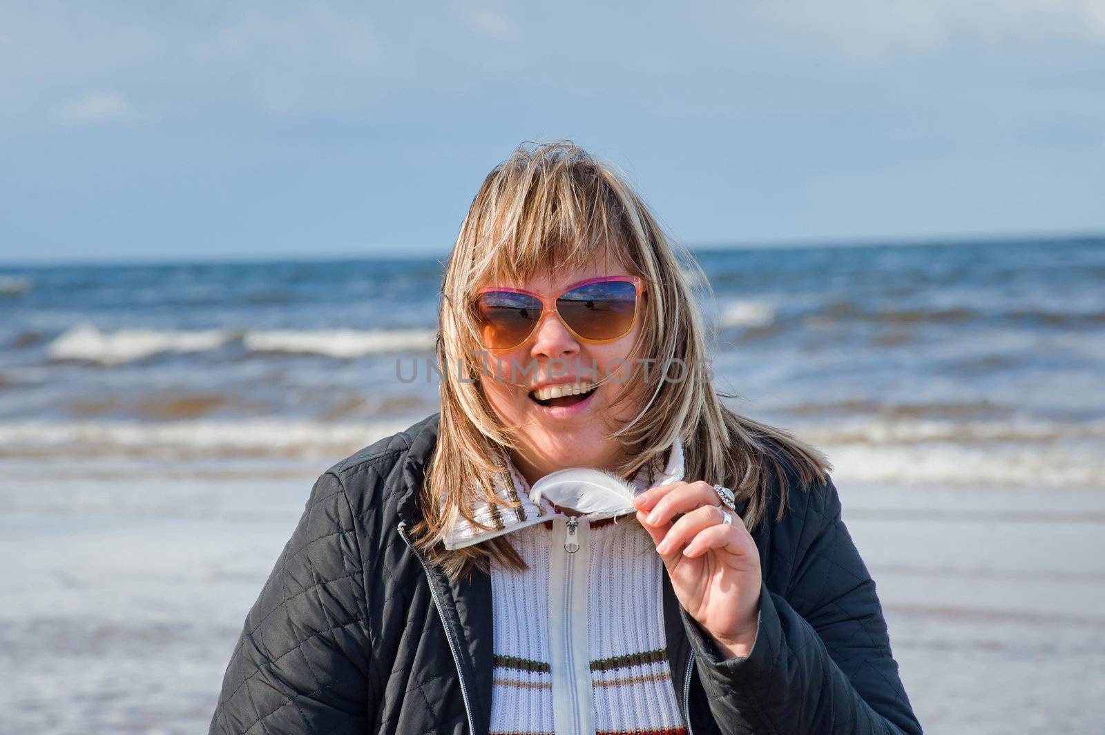 Portrait of mature chubby woman relaxing at the Baltic sea in autumn day.