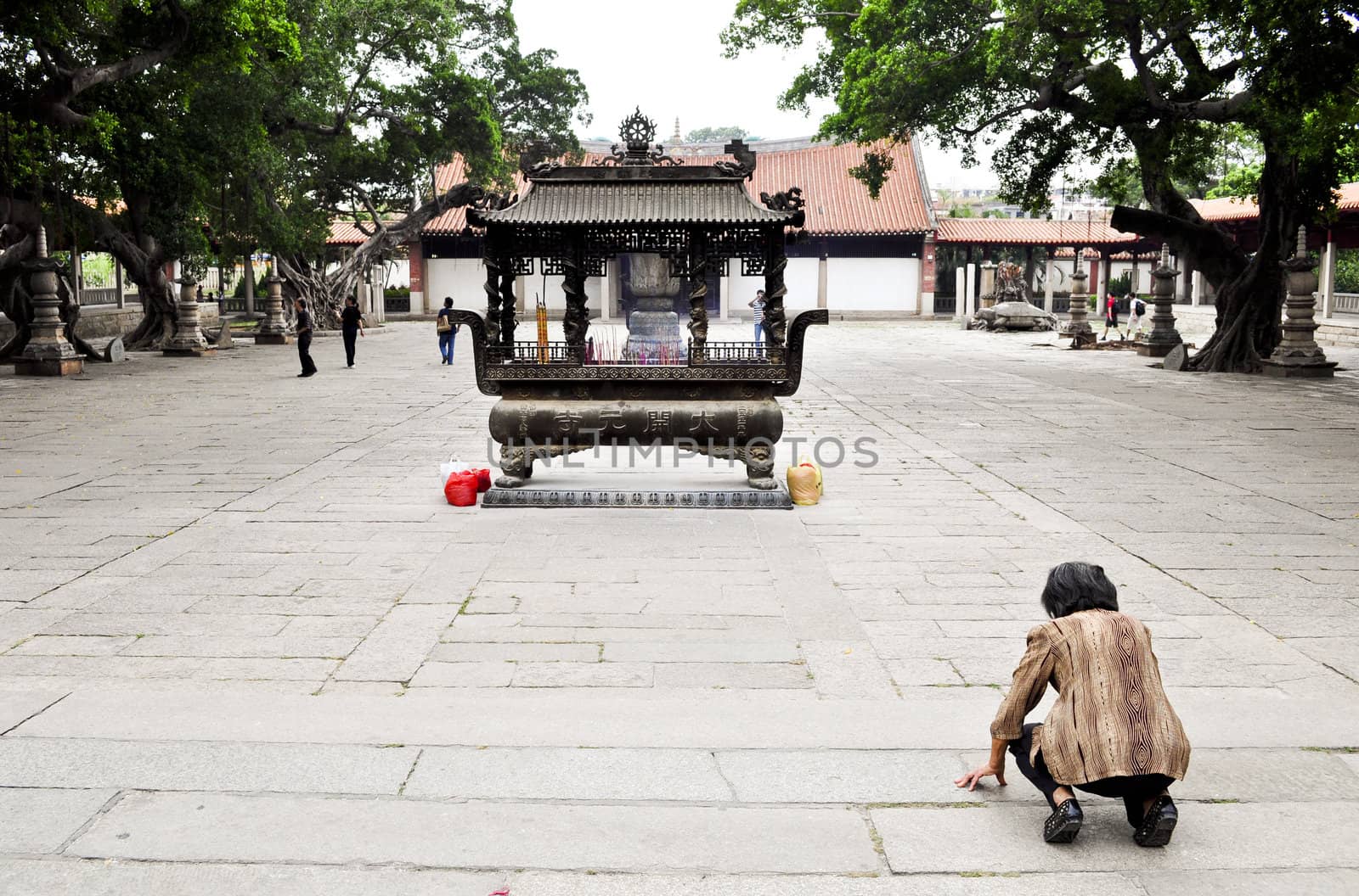 Quanzhou, China - October 07:  An old woman prays to a small shrine at a famous temple in Quanzhou, China on October 7, 2010.