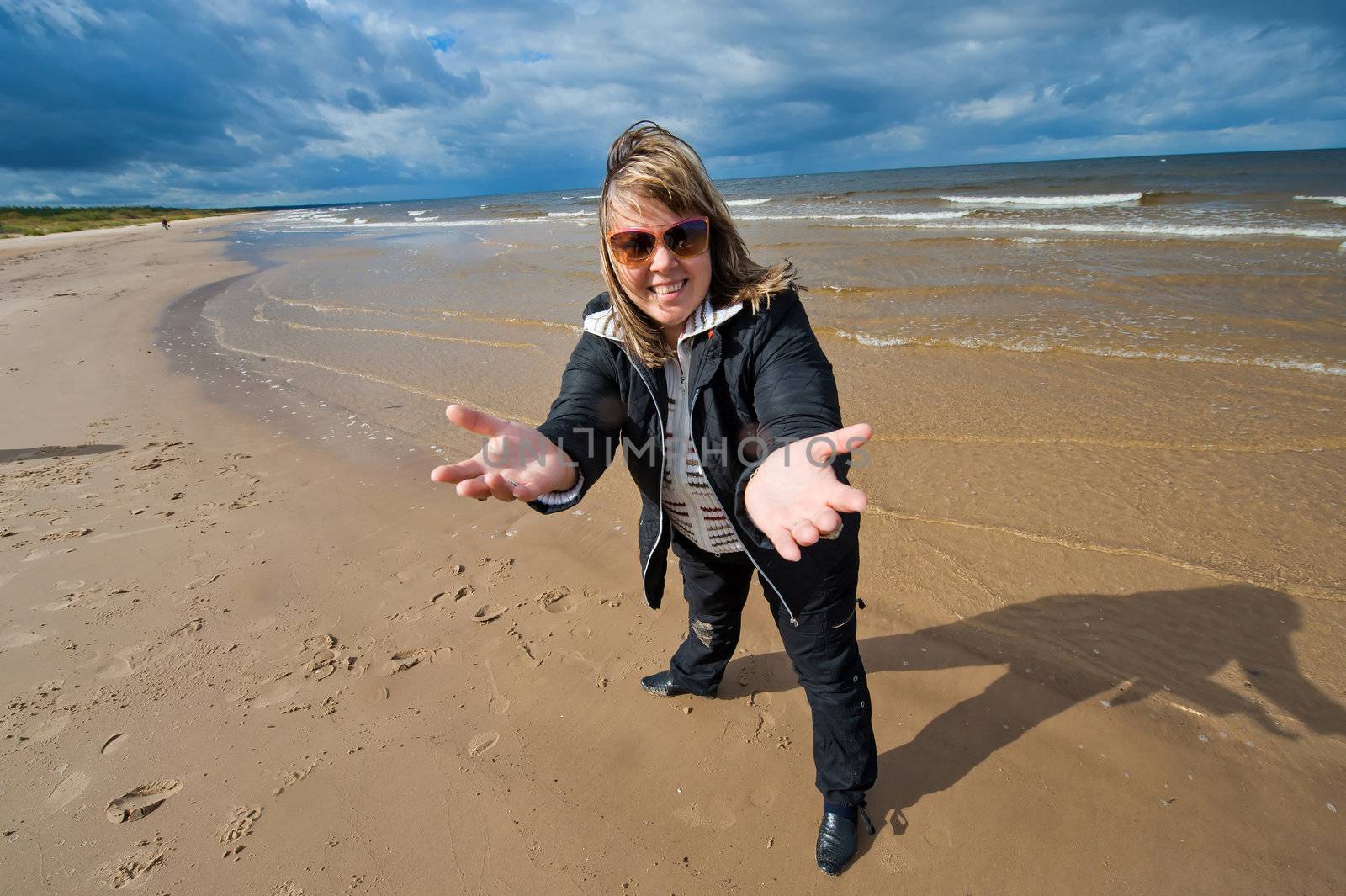 Mature funny attractive woman in sunglasses relaxing at the Baltic sea in autumn day.