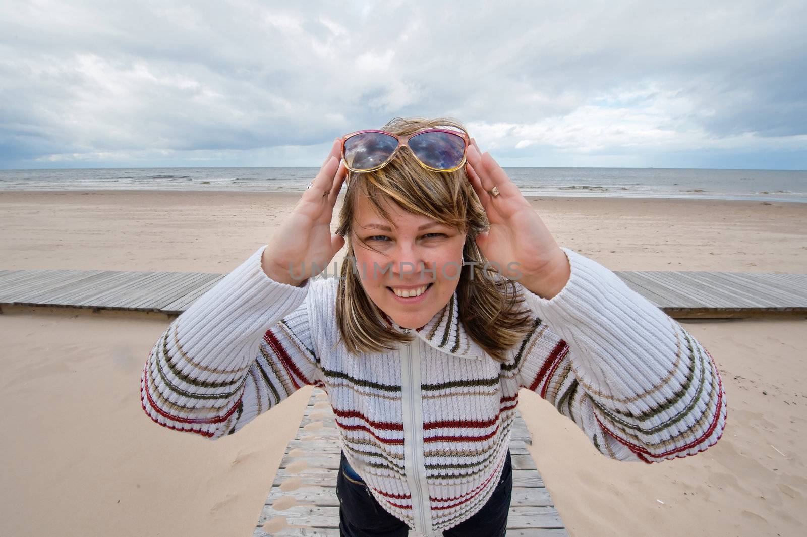 Portrait of mature attractive woman in sunglasses relaxing at the Baltic sea in autumn day.