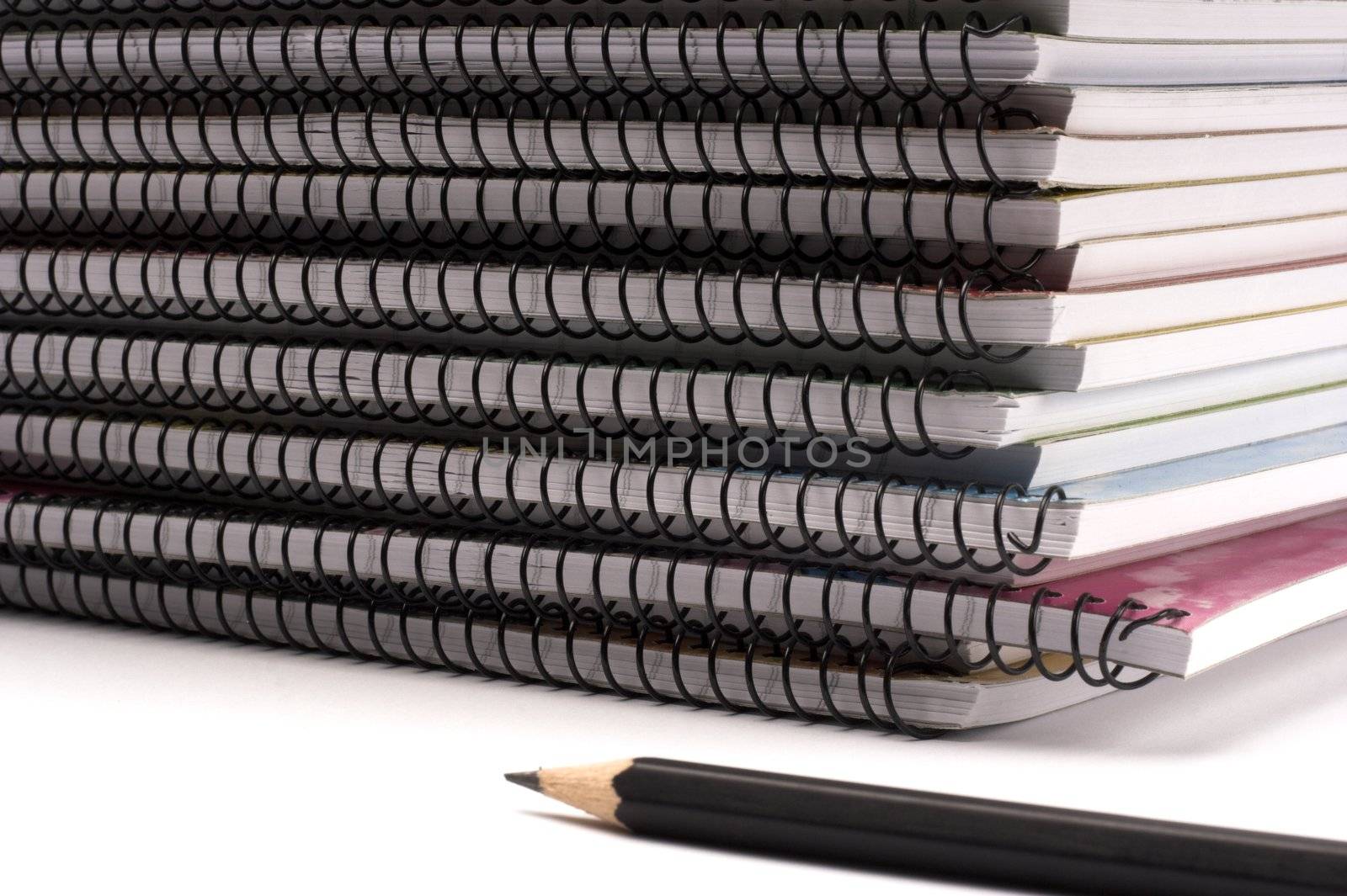 A pile of notebooks with pen