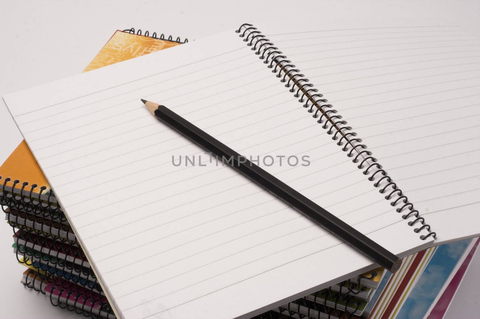 A pile of notebooks with pen