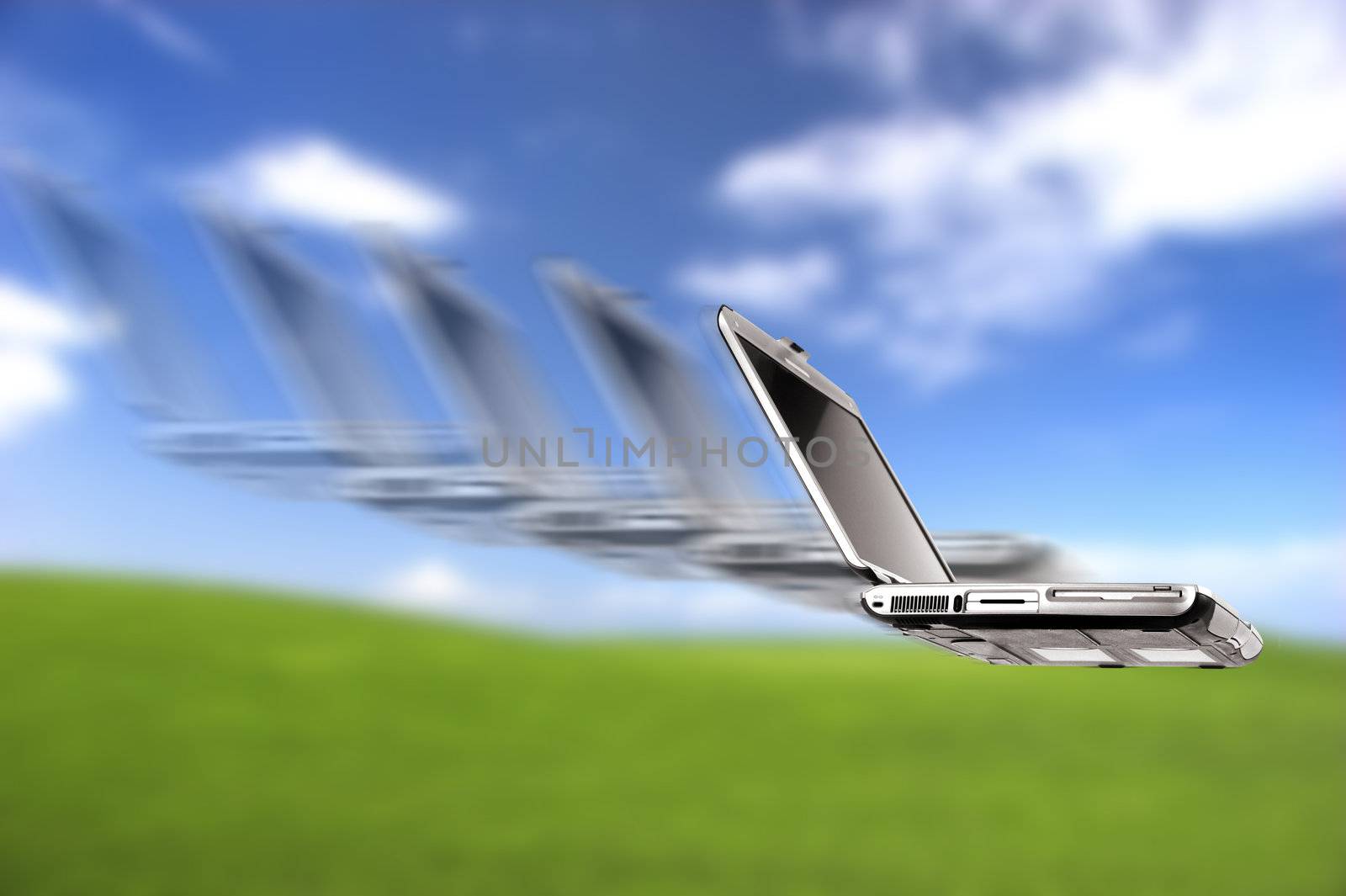 Laptop flying over a beautiful green meadow