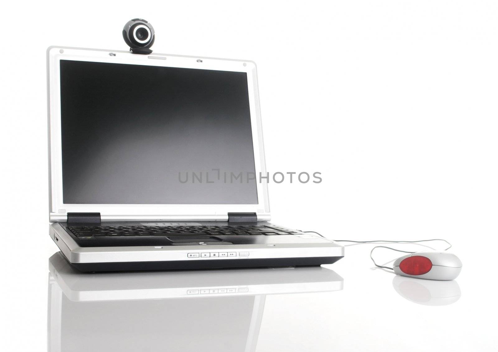 Laptop with a mouse and a webcam over a table with reflection