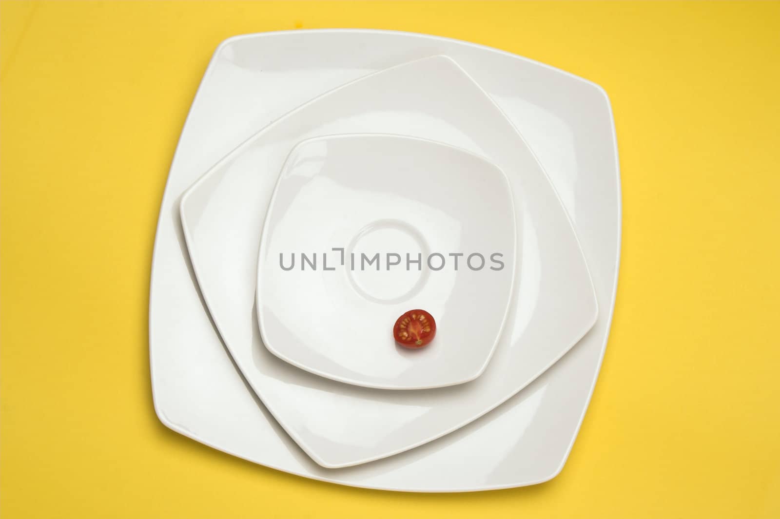 Tomatos in white plate over yellow