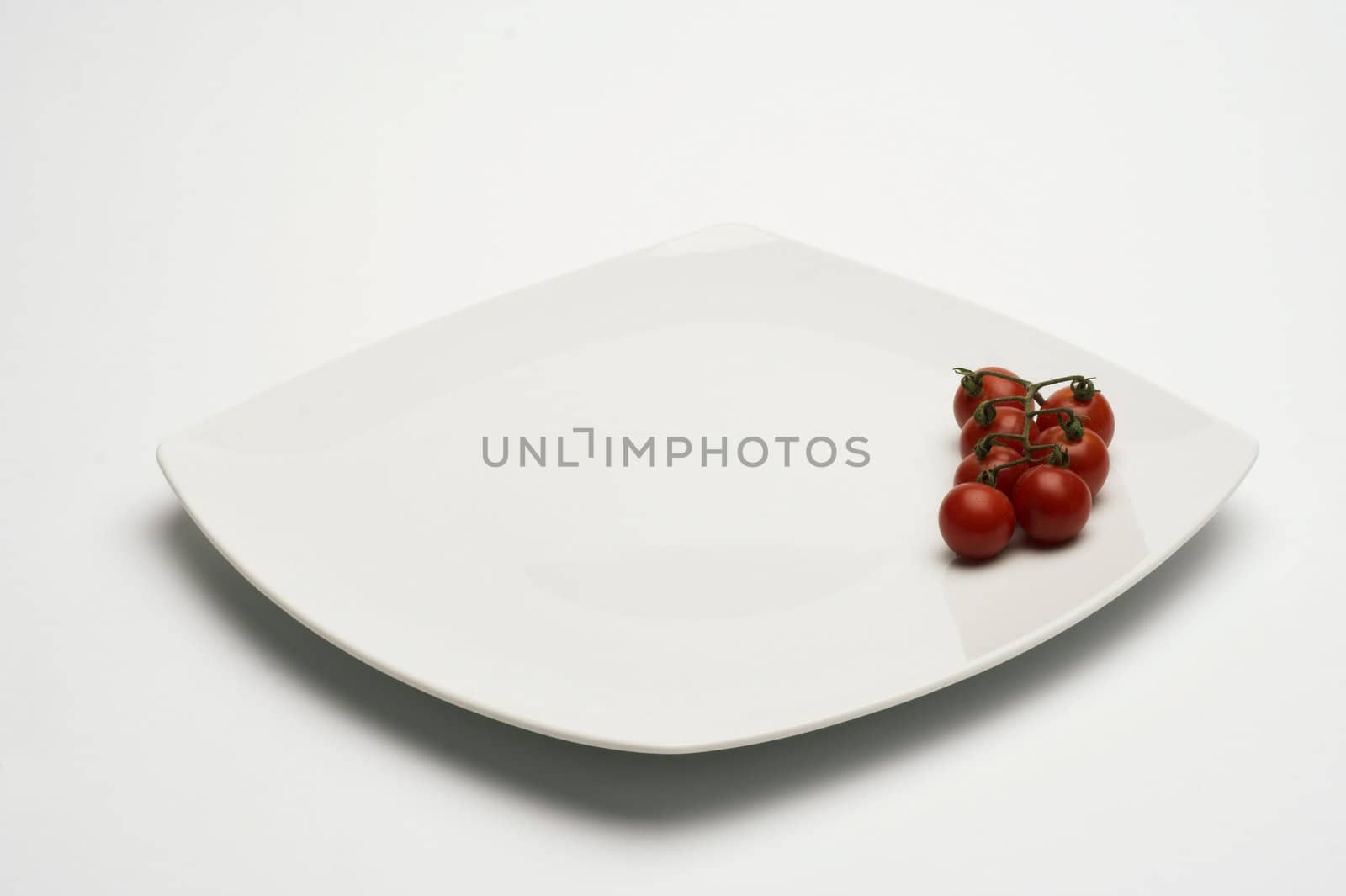 Tomatos in white plate over white