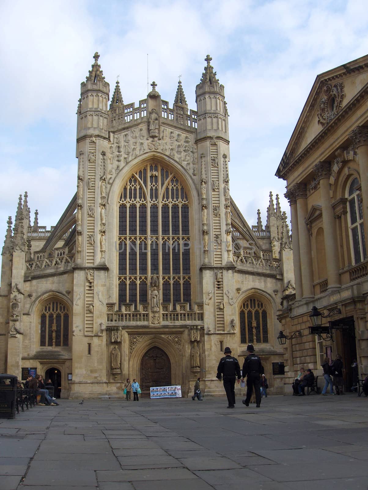 Two Bobbies stroll the square in front of the Abbey in Bath, England.