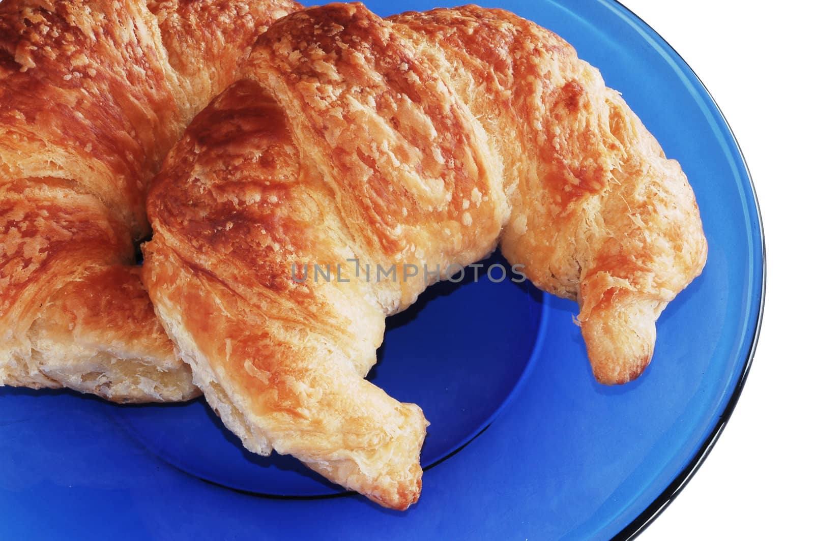 Two croissants on blue plate.