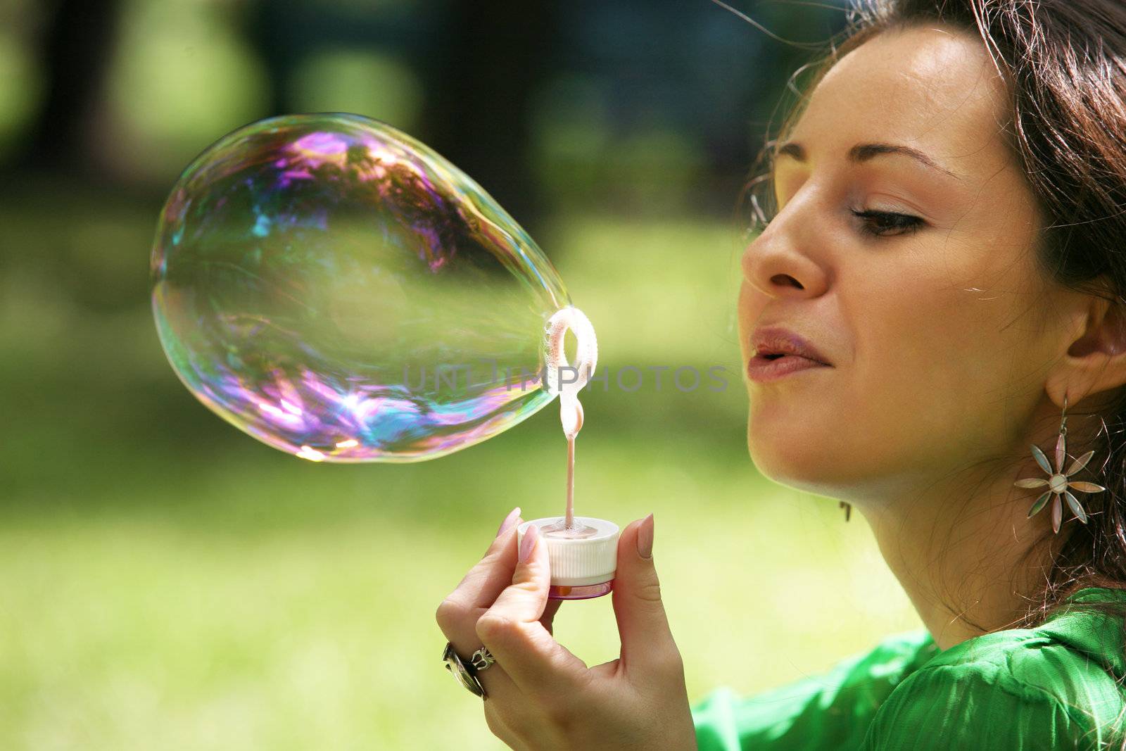 The girl makes big soap bubble in park