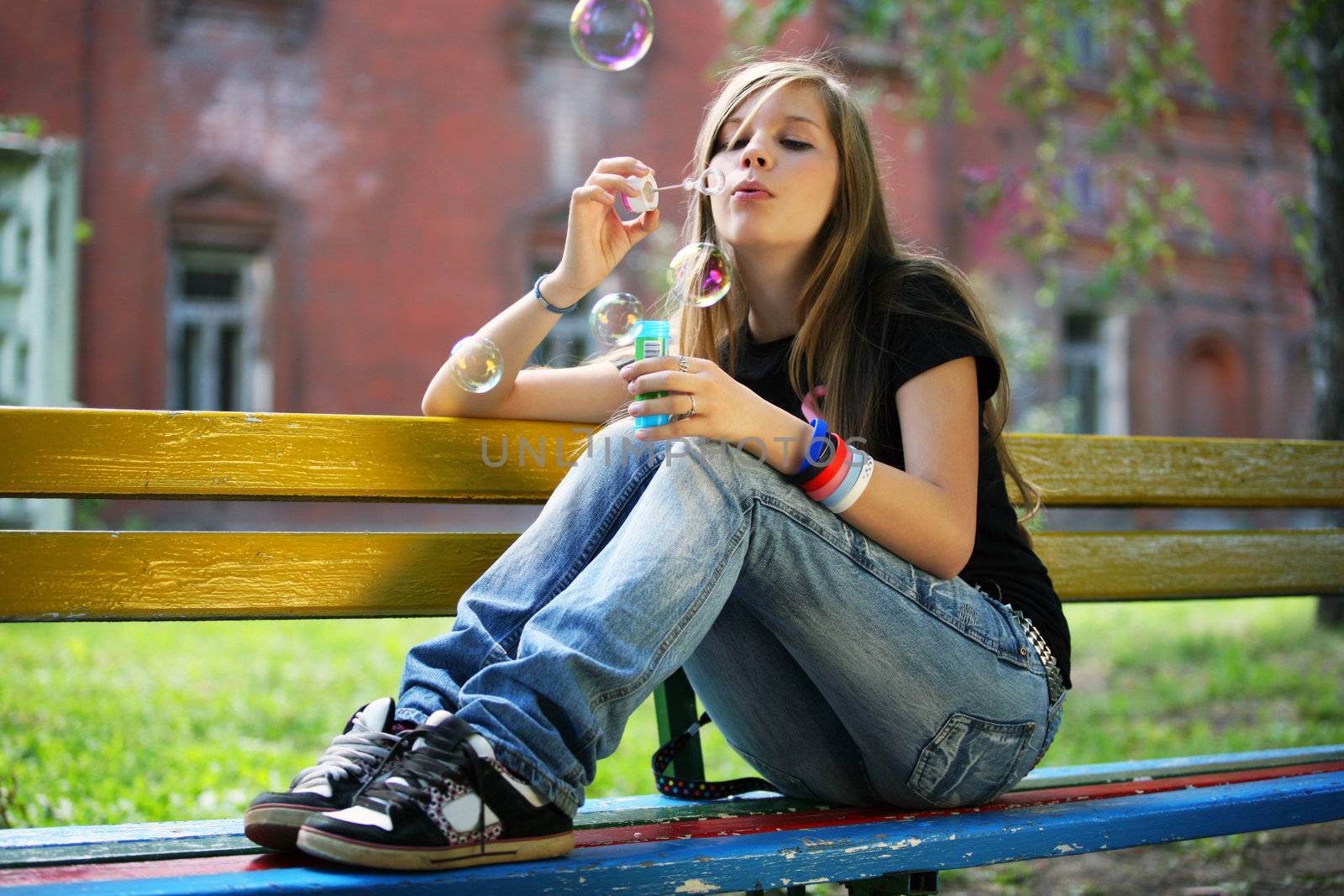 The young girl makes soap bubble
