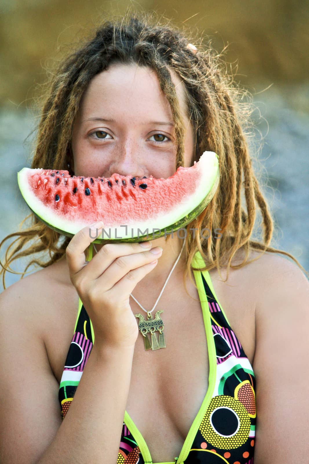 young beautiful smiling dreadlock woman with a slice of watermelon