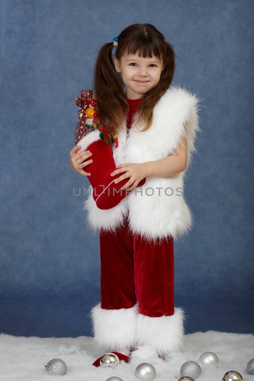 The little girl received a Christmas gift on a blue background