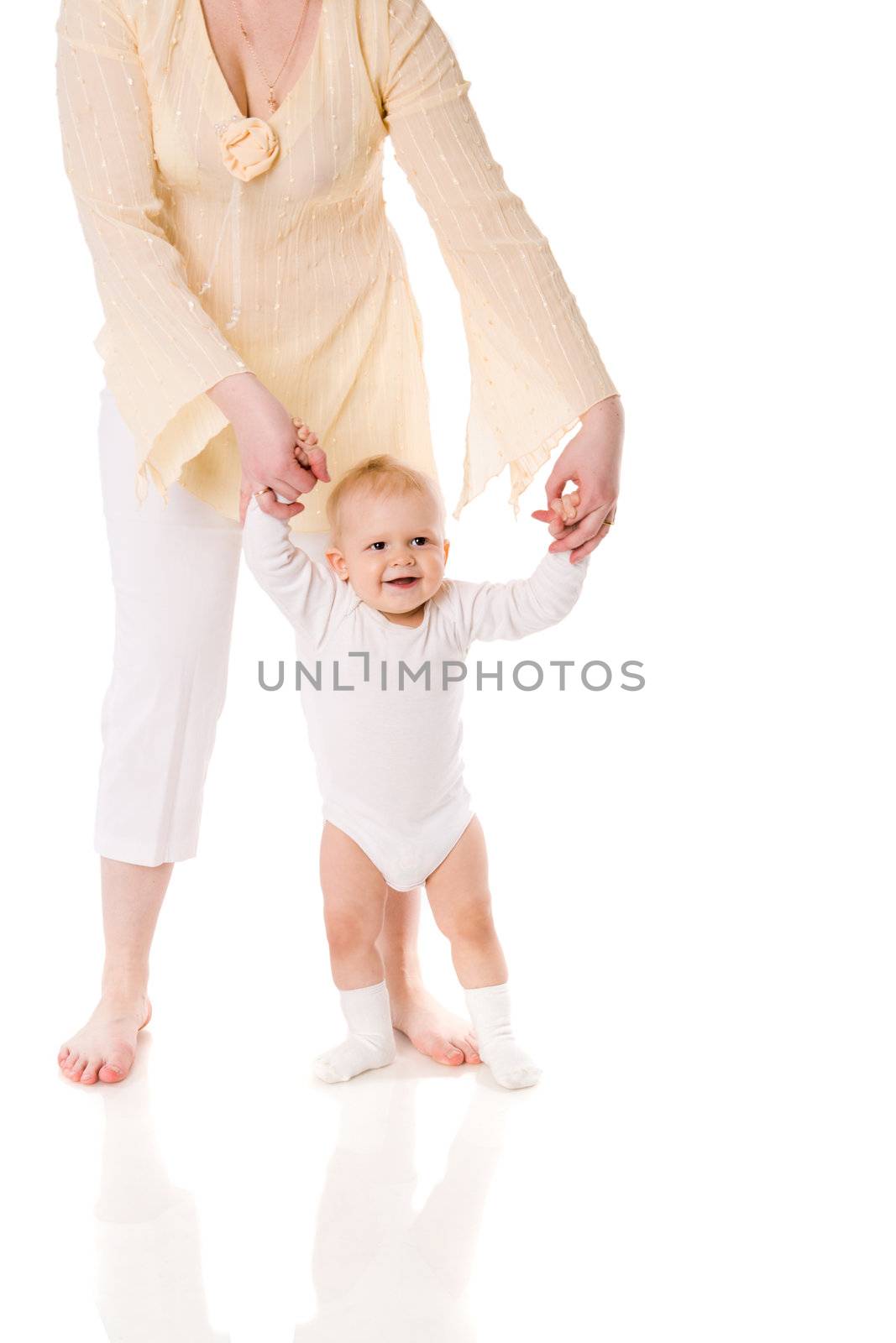 Mother holding daughter's hands first steps isolated on white