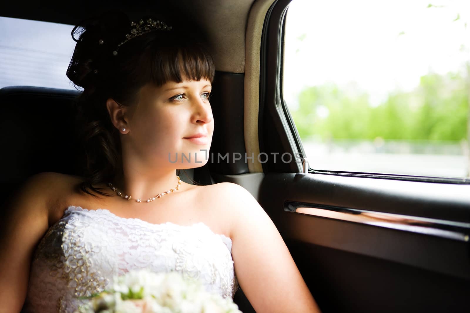 Bride sitting in car before wedding begins thoughtful look