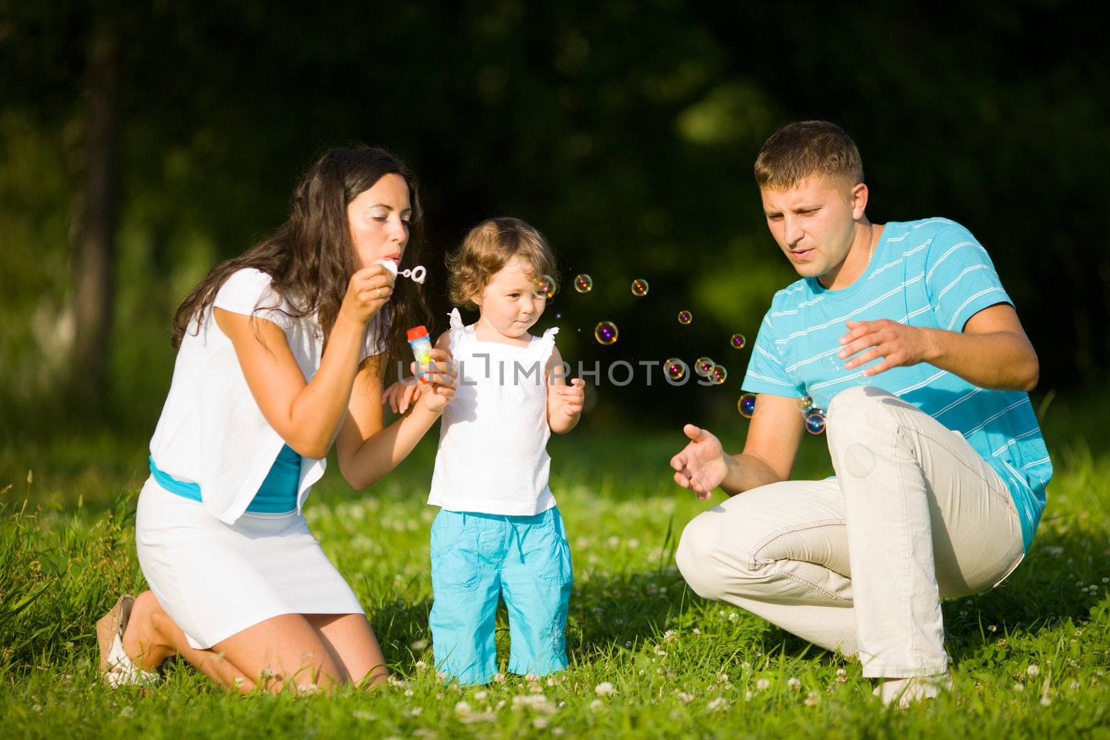 Happy Family making soap bubbles outdoors summer