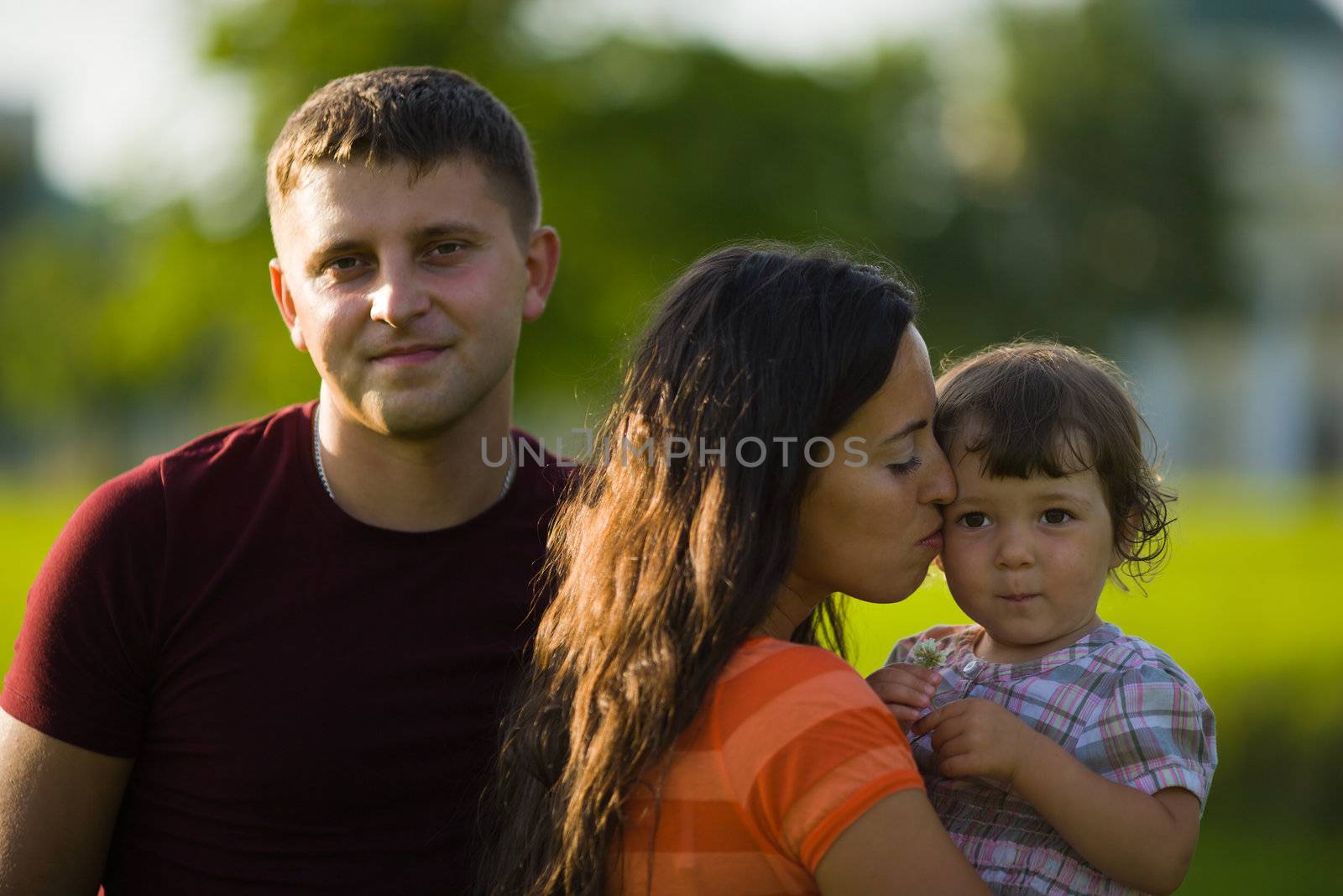 Happy Family with kid together outdoors summer evening