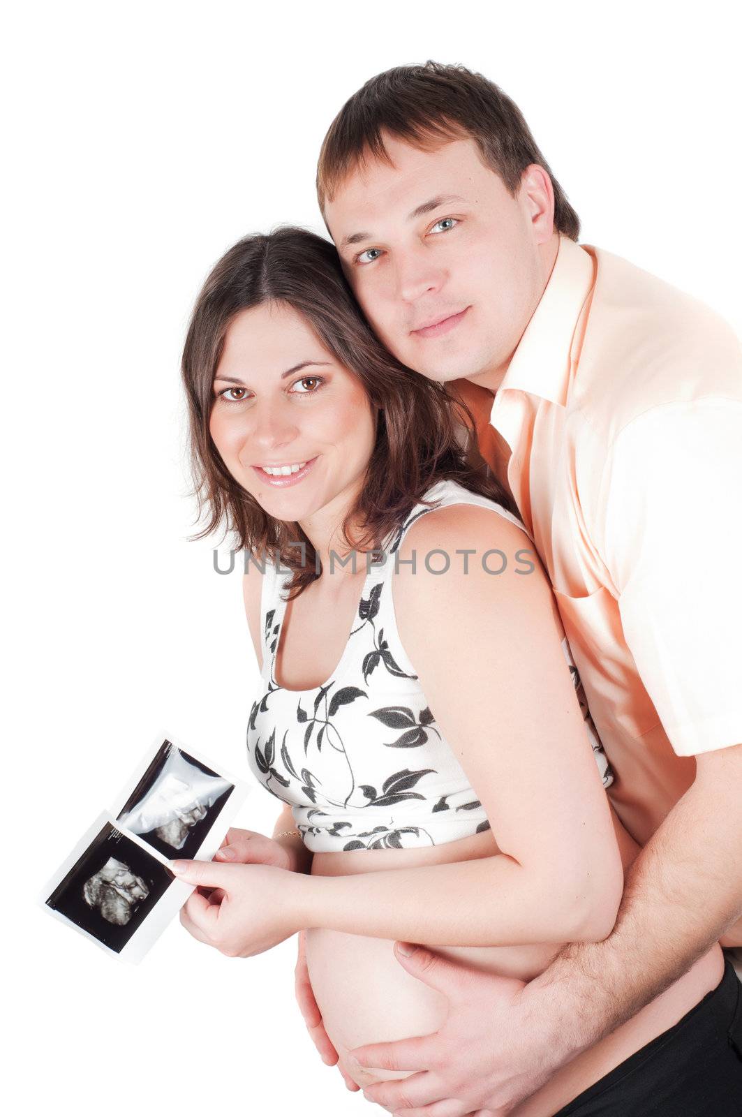 Happy young couple holding a sonogram of their child