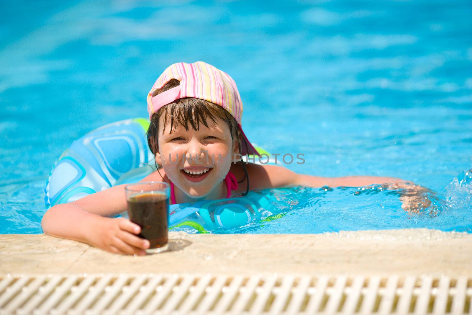 Little girl drinking soda in pool summer holidays