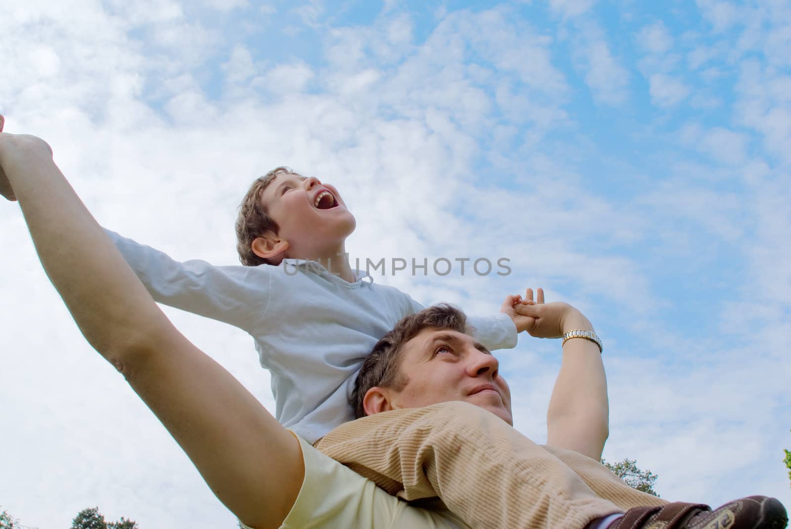 Father and his son against the blue sky