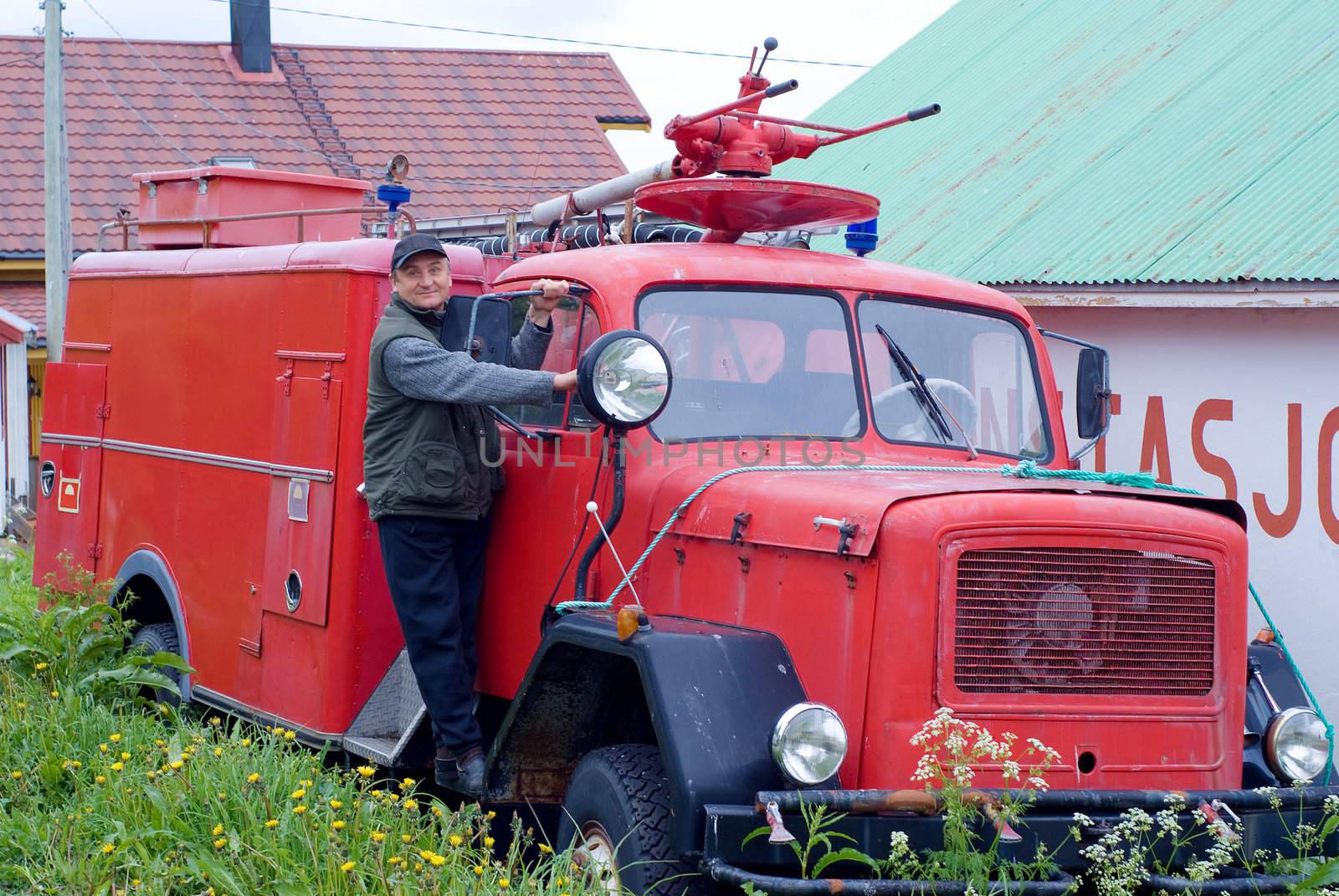 The man is on an ancient fire-engine with a lantern