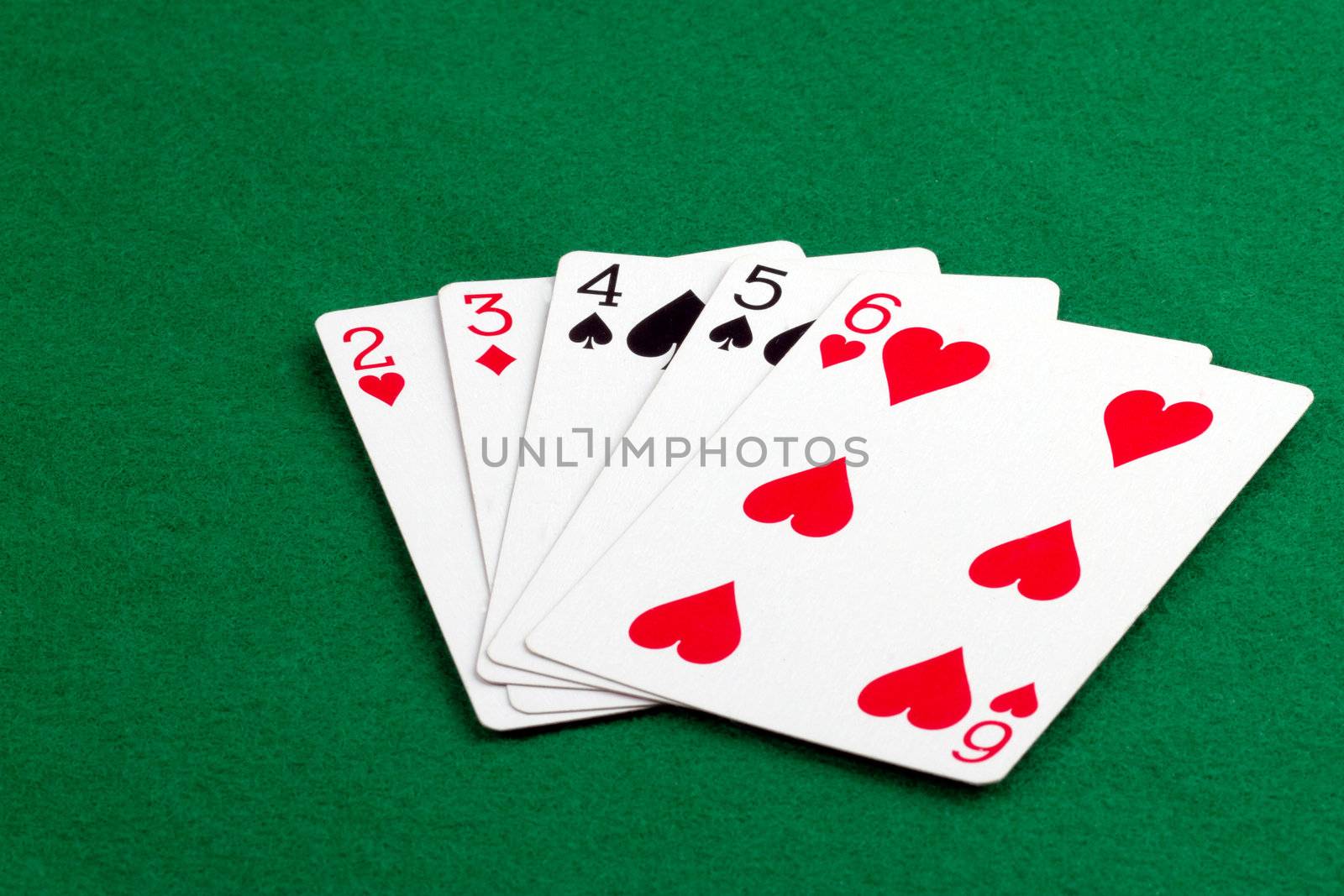 Poker hand with a straith on green felt