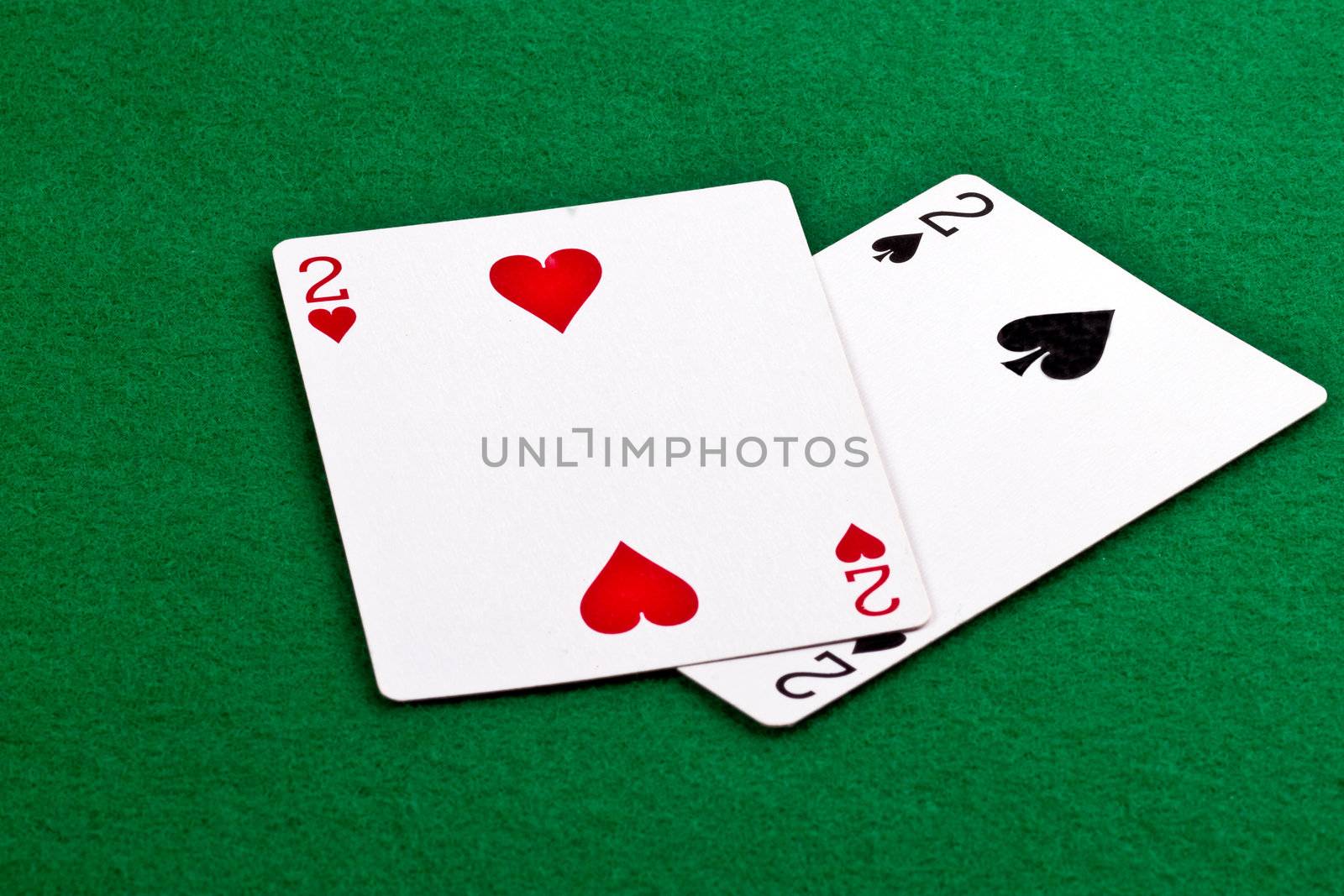 Poker hand with a pair of deuces on green felt