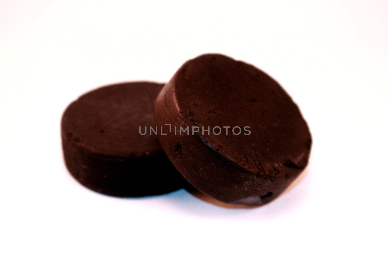 A pair of hockey pucks isolated on a white background. Used hockey pucks for sports and recreation.