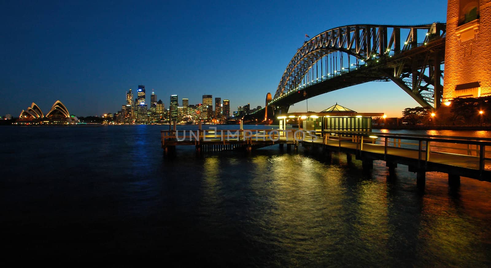 panorama photo of sydney cbd, opera house and harbour bridge during sunset