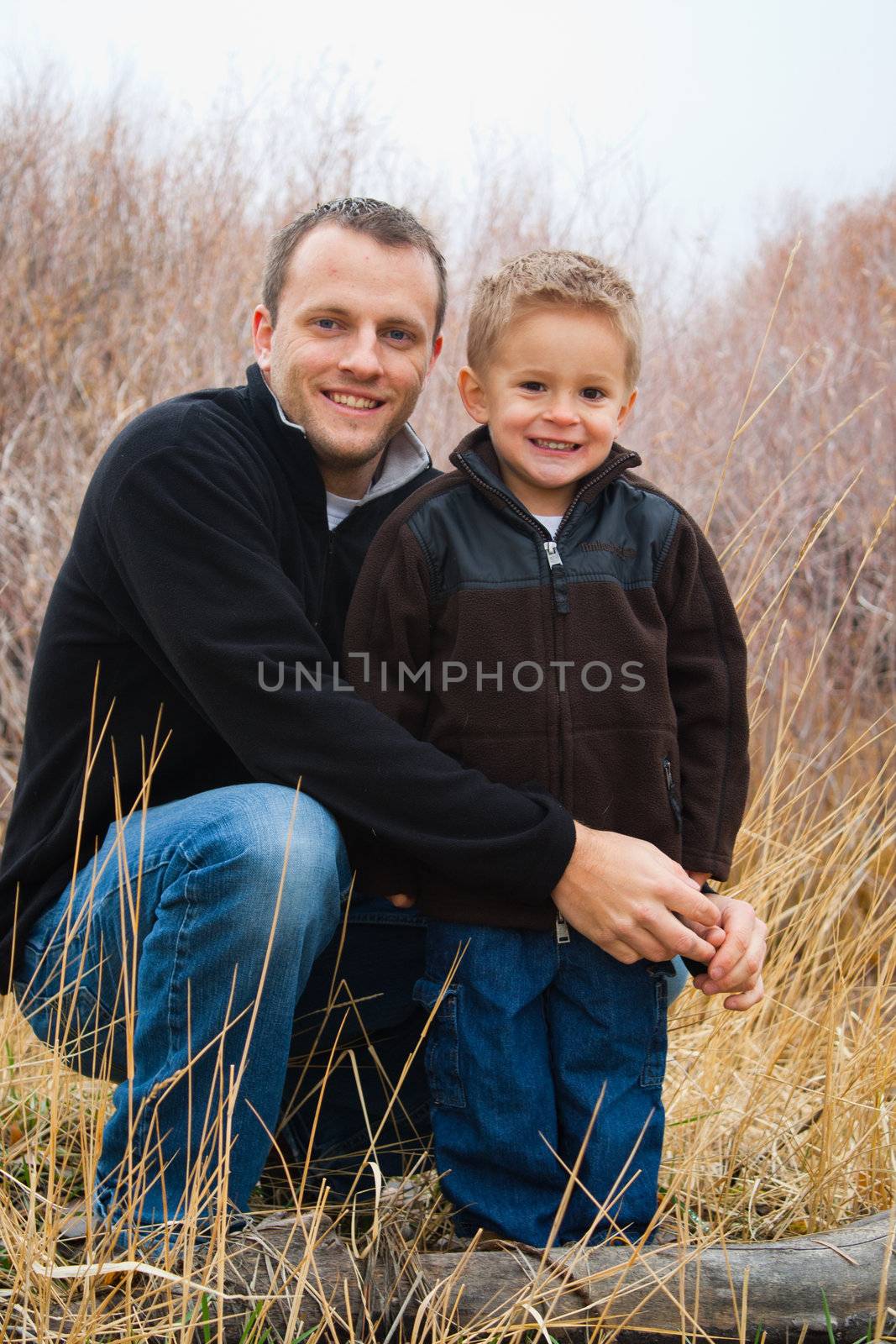 A father and son hanging out in Nature.  They may be camping, hiking or just exploring.