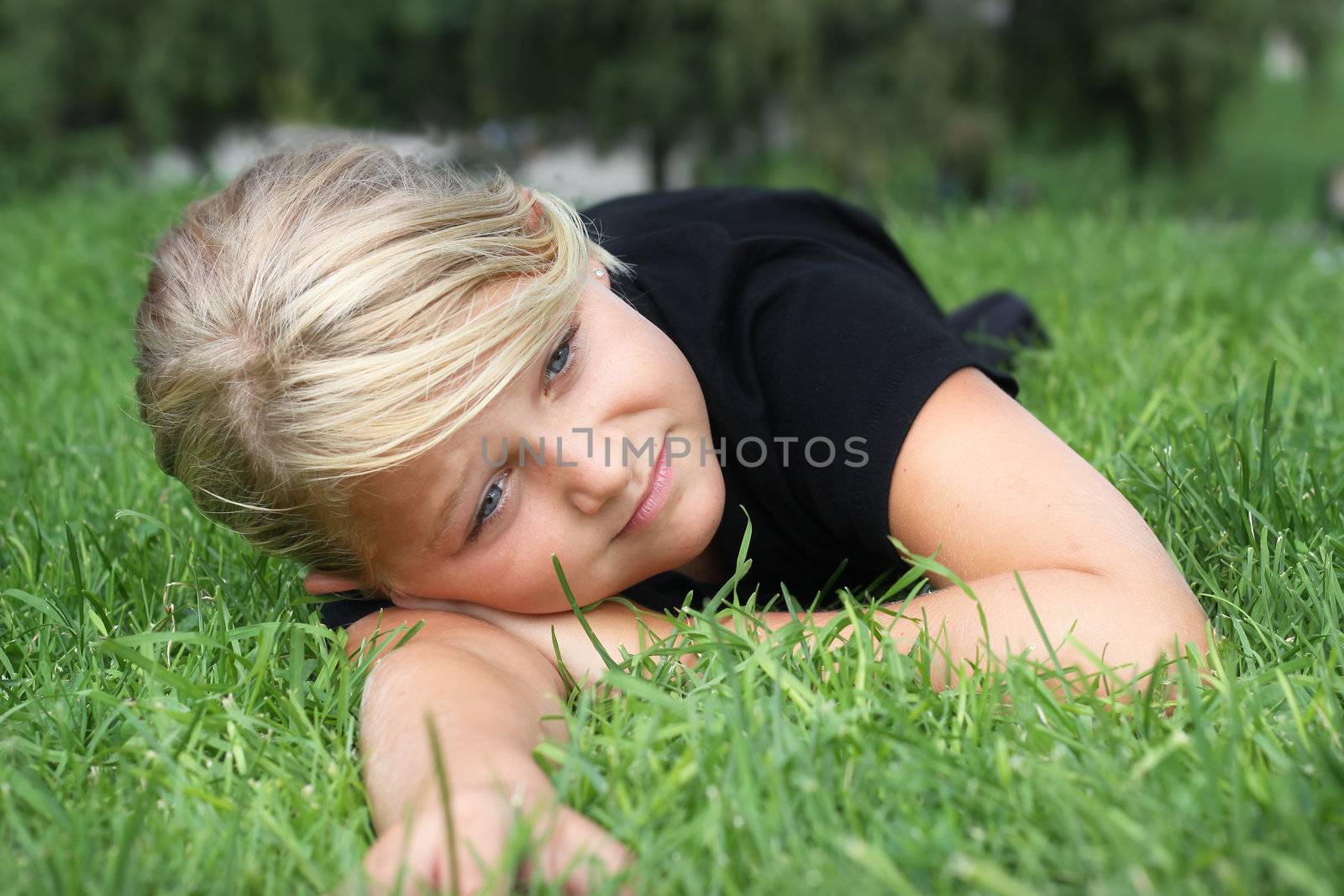 A young girl relaxing on green grass