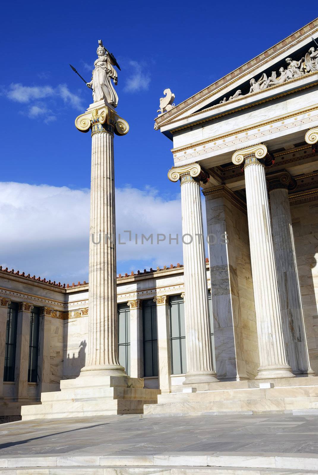 The National Academy Building in Athens. The building, which was built from 1859-1885, is located on the south of The University of Athens' main building (Panestimio street). In front of the facade stand two high ionic columns, which bear the colossal statues of Athena and Apollo.