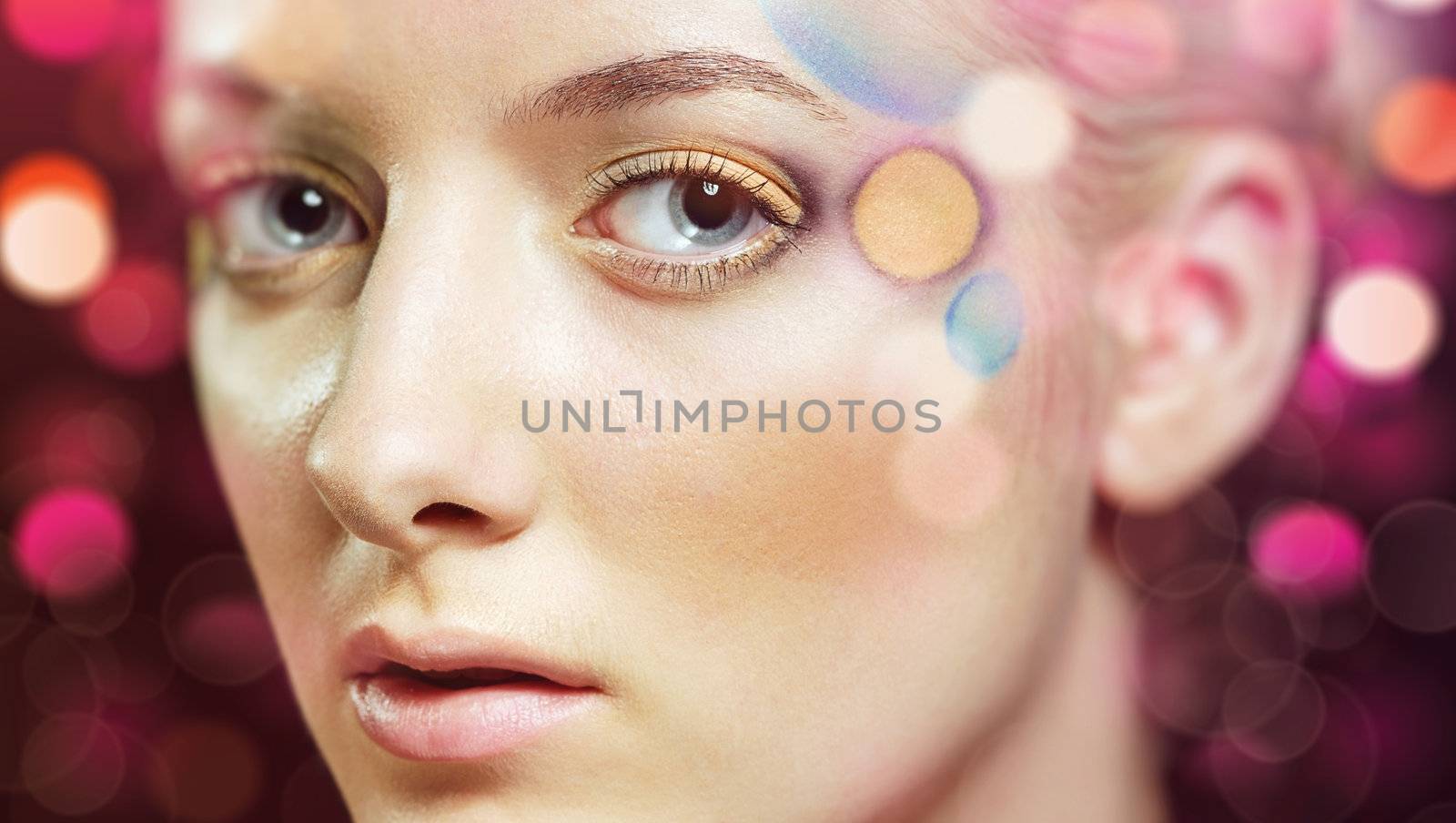 Portrait of a beautiful dreaming woman in coloured lens flares