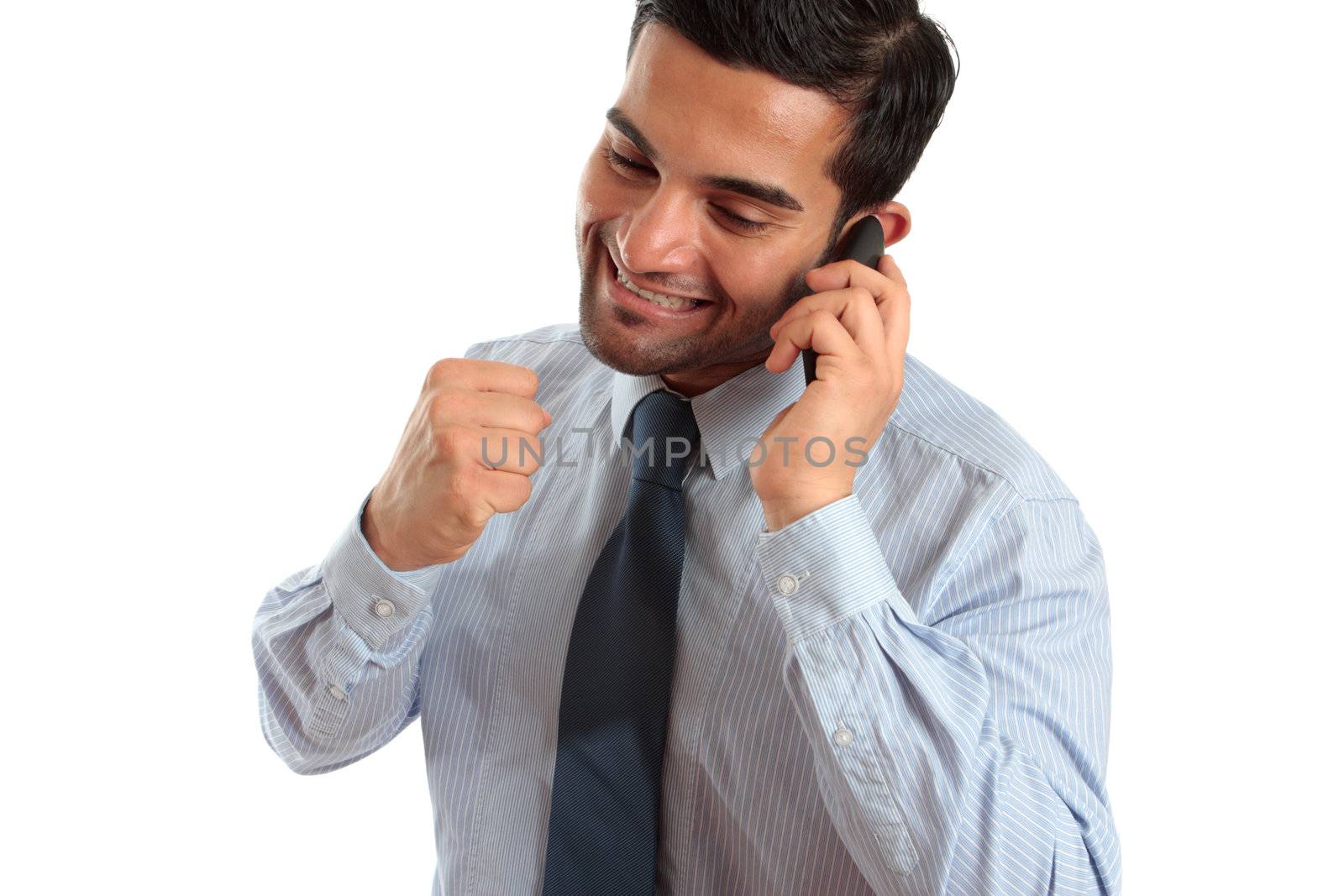 A very happy businessman or salesman on a telephone call and making a fist of success or achievement.  Sales deal, new job, promotion etc.