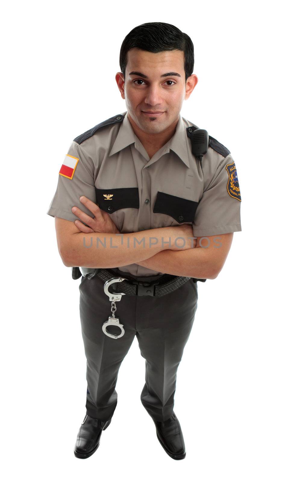 A male prison guard warden or policeman in uniform with duty belt and radio unit.   Standing with arms crossed and looking up.  White background