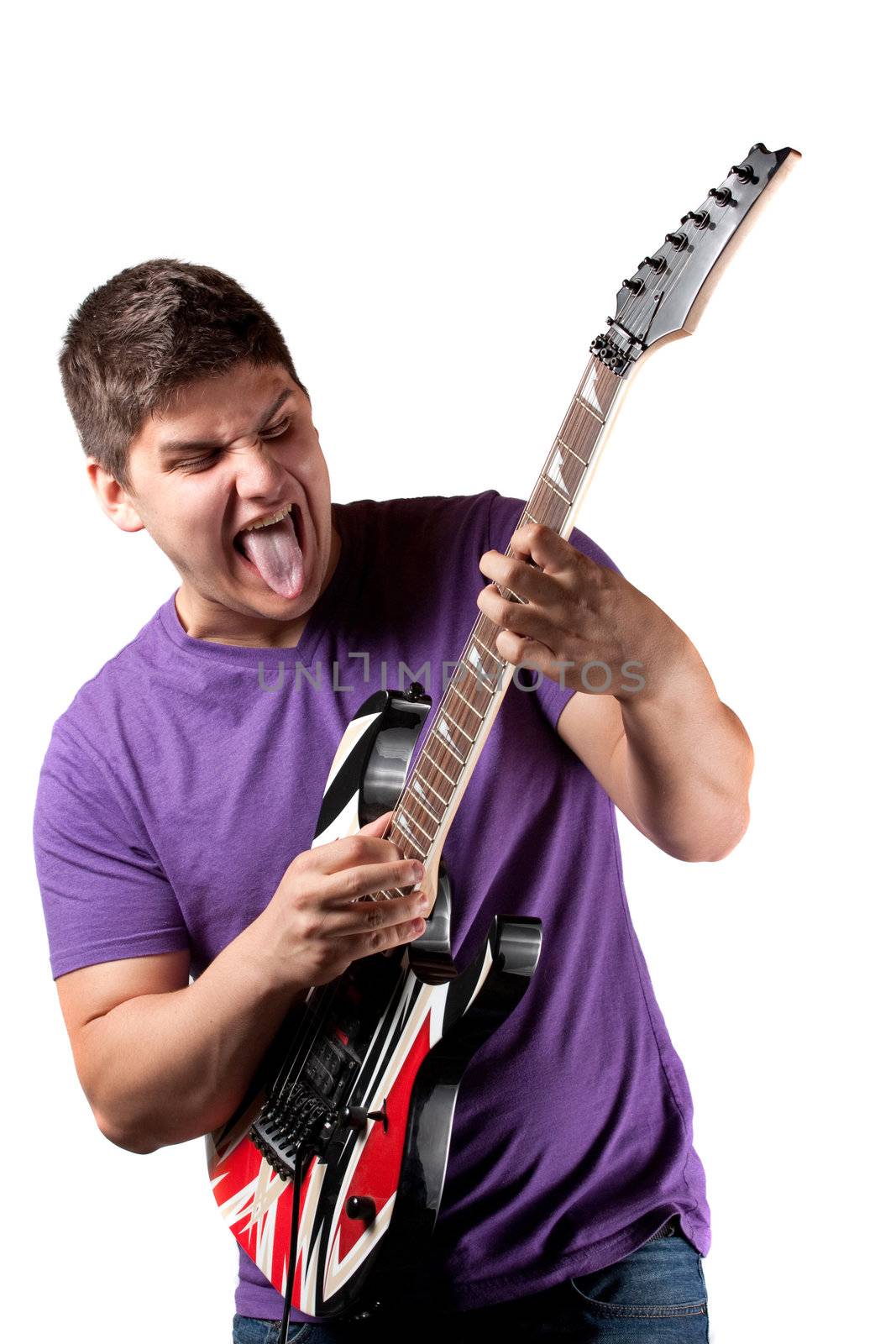 A man in his late teens rocks out while playing his electric guitar.