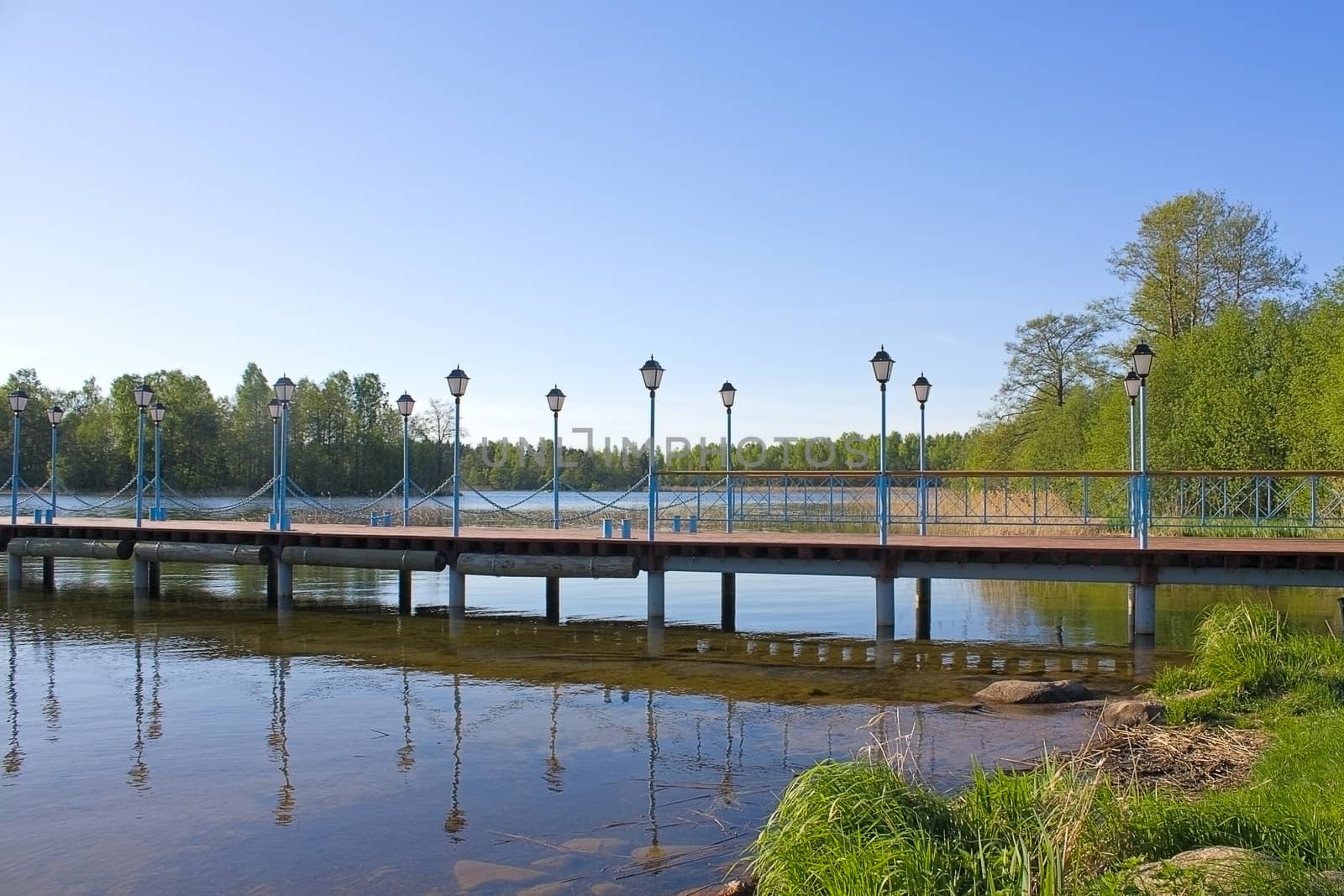 Wooden pier with lanterns on the lake Valdai, Russia.