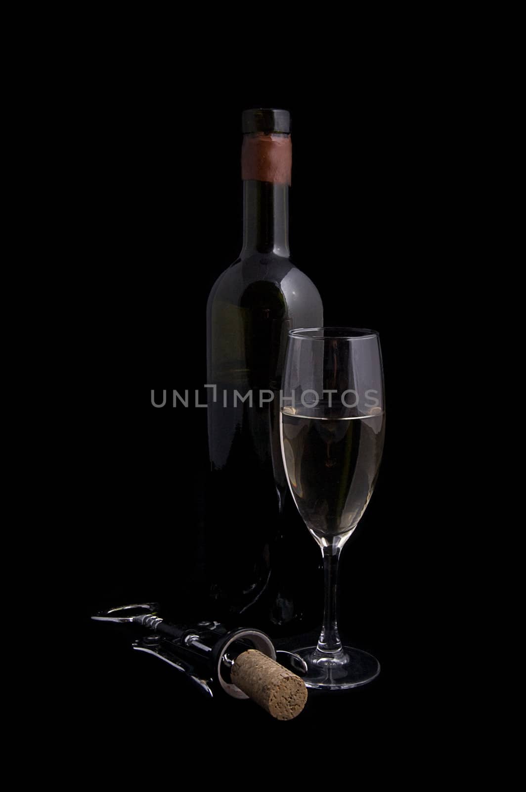 White wine bottle and glass with corkscrew over black