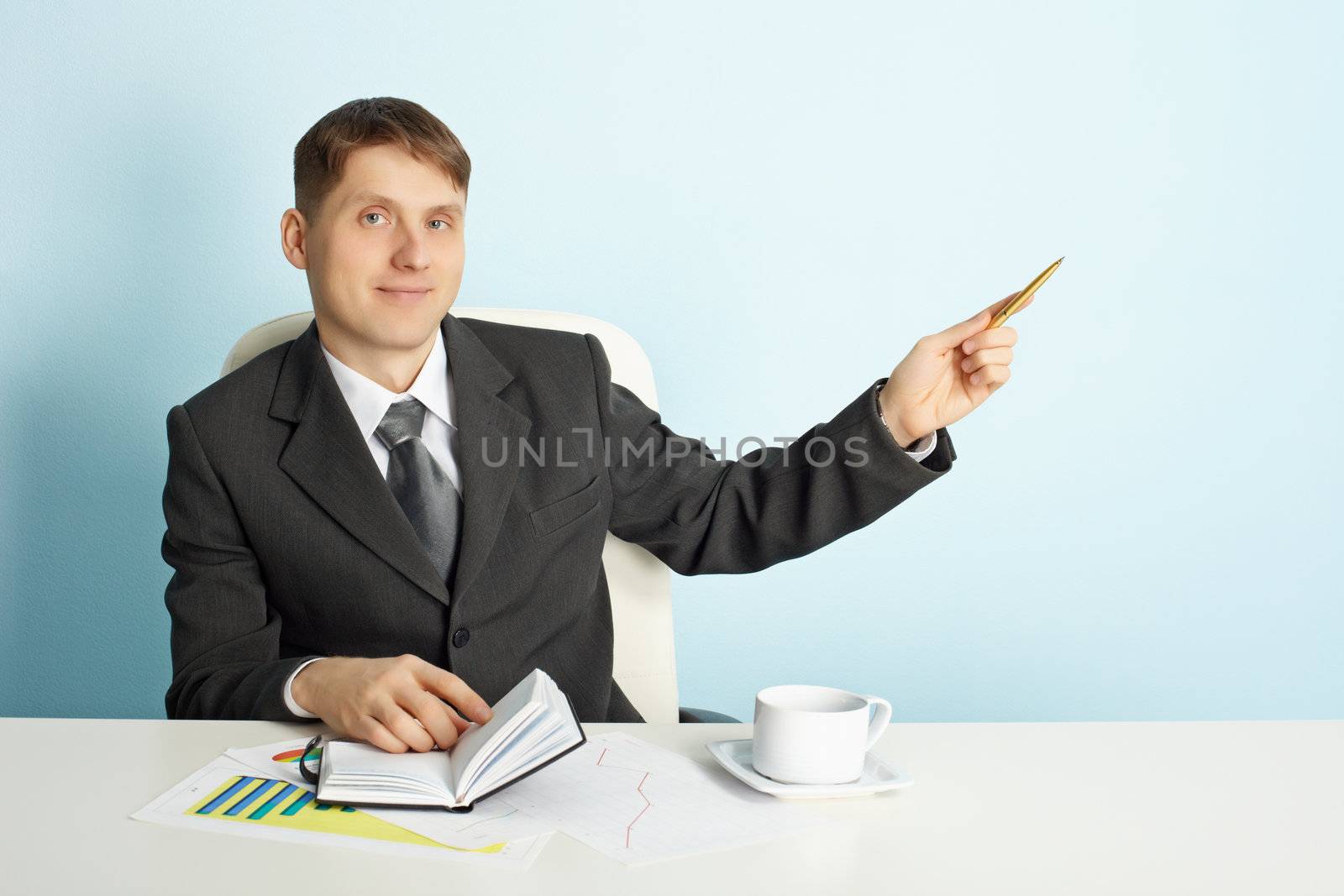 A young businessman shows the direction of using the pen