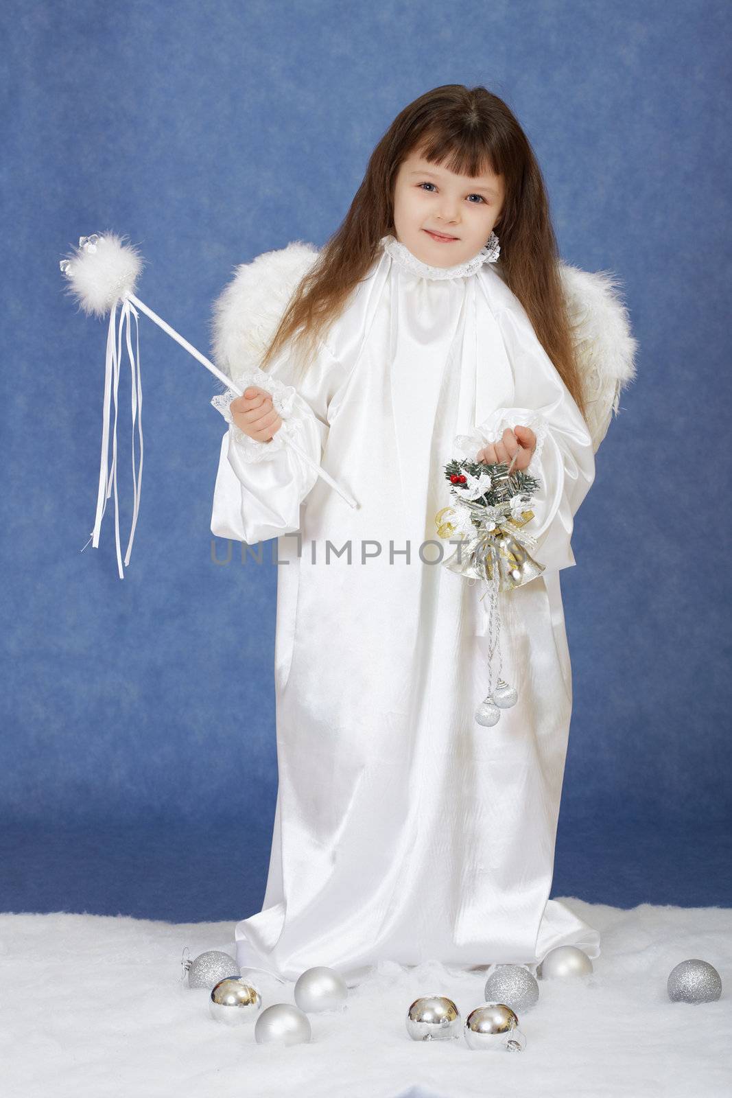 The little girl in a suit of angel on a dark blue background
