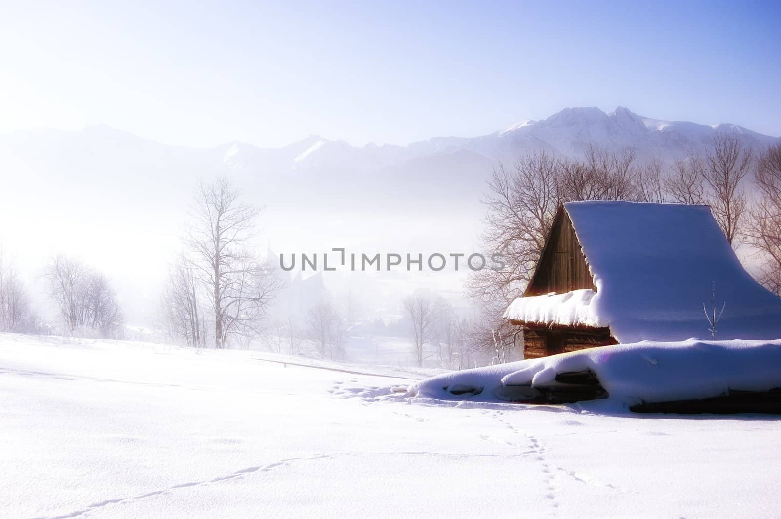 Winter scene in mountains. Old house and snow