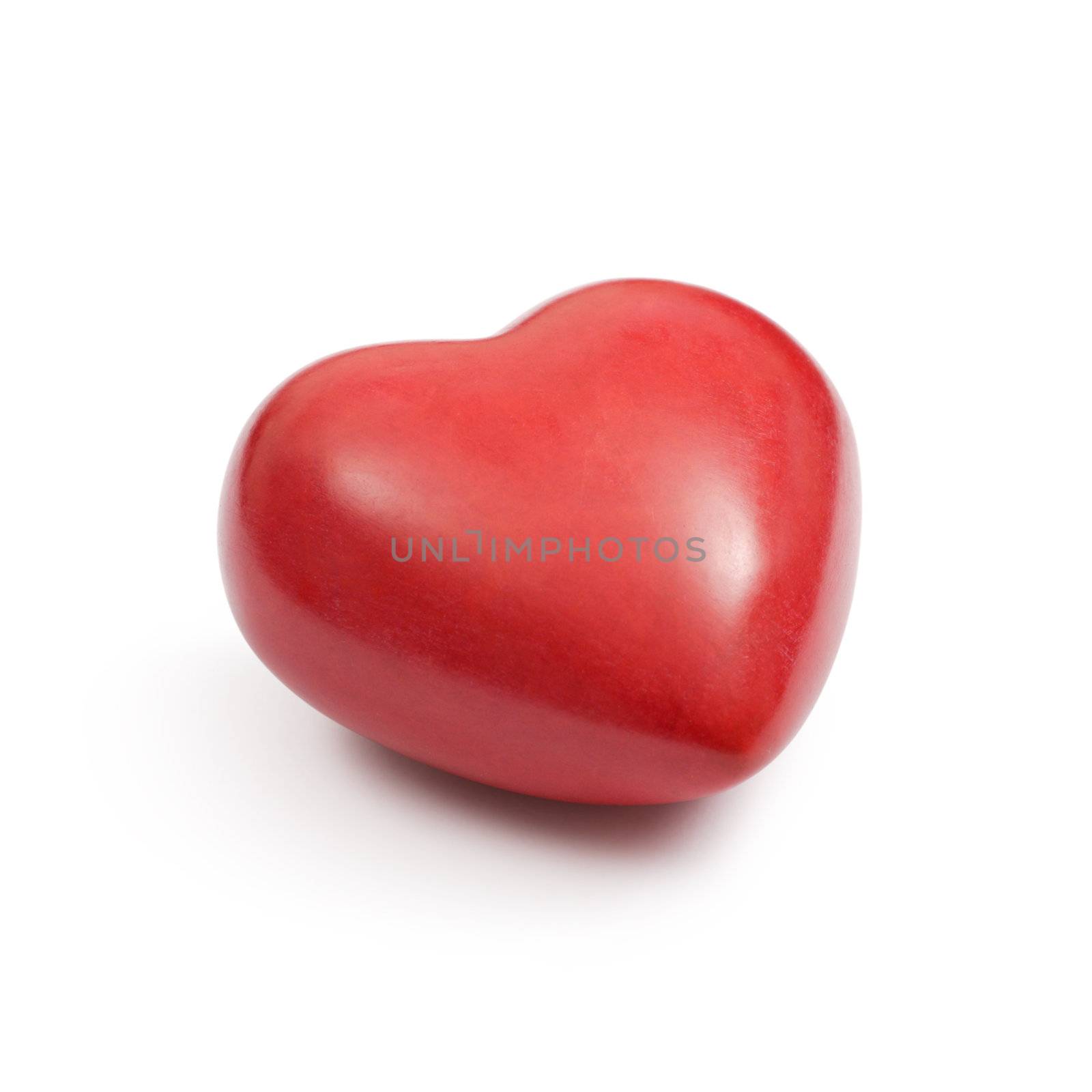 Angle photo of a heart-shaped red stone on a white background.  Clipping path included.