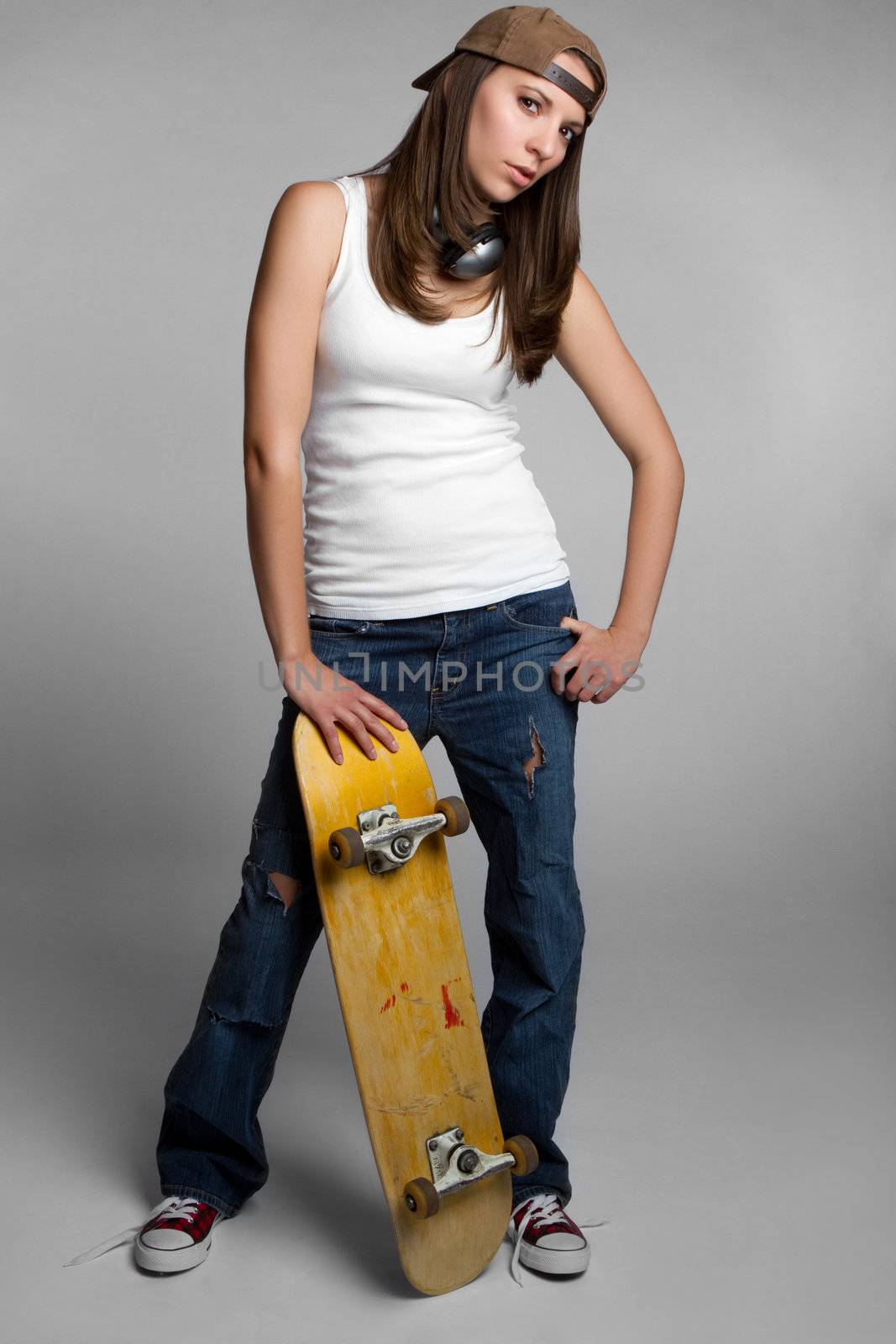 Pretty skater girl holding skateboard