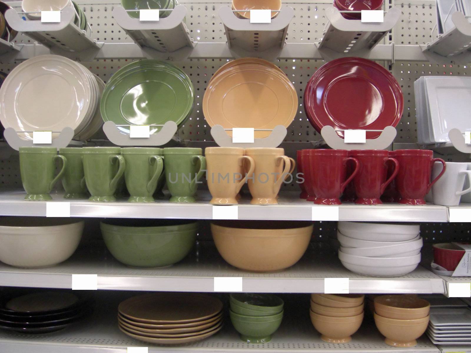 A whole range of colorful kitchen items are neatly displayed on shelves inside a retail store.