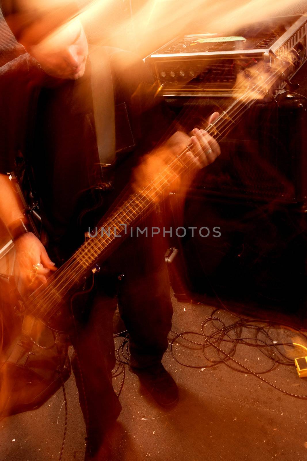 Blurry atmospheric abstract noisy hazy image of a bass player rippin' thru songs. Shot with slow shutter speed and flash for lots of movement and effect.
