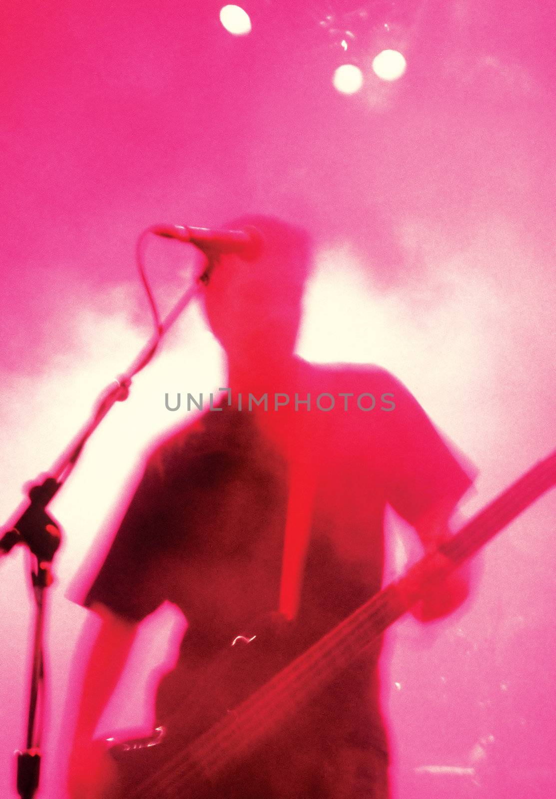 Grainy blurry atmospheric abstract noisy hazy image of a bass player rippin' thru songs. Shot with 3200 iso 35mm film in low light with slow shutter speed.
